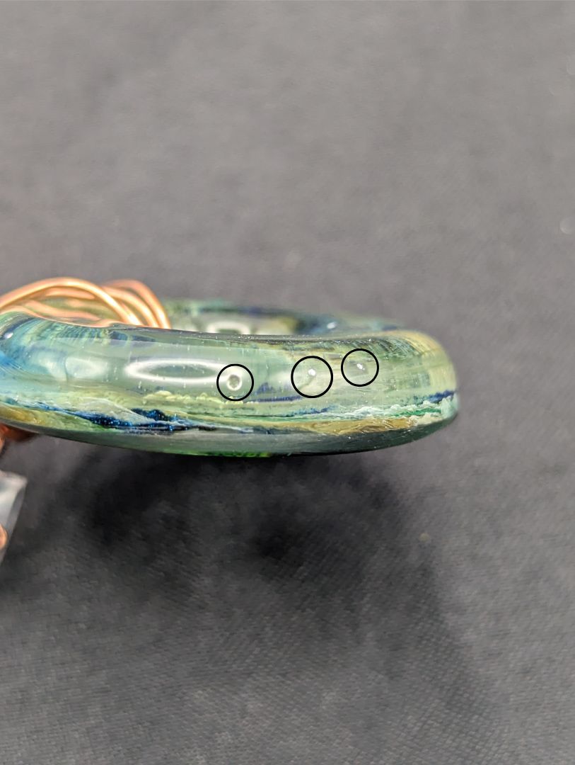 Wire Wrapped Donut Resin Pendant Necklace - Petri Effect with shades of blue, green, & yellow swirls. Resin Necklace on a rose gold colored stainless steel metal chain.