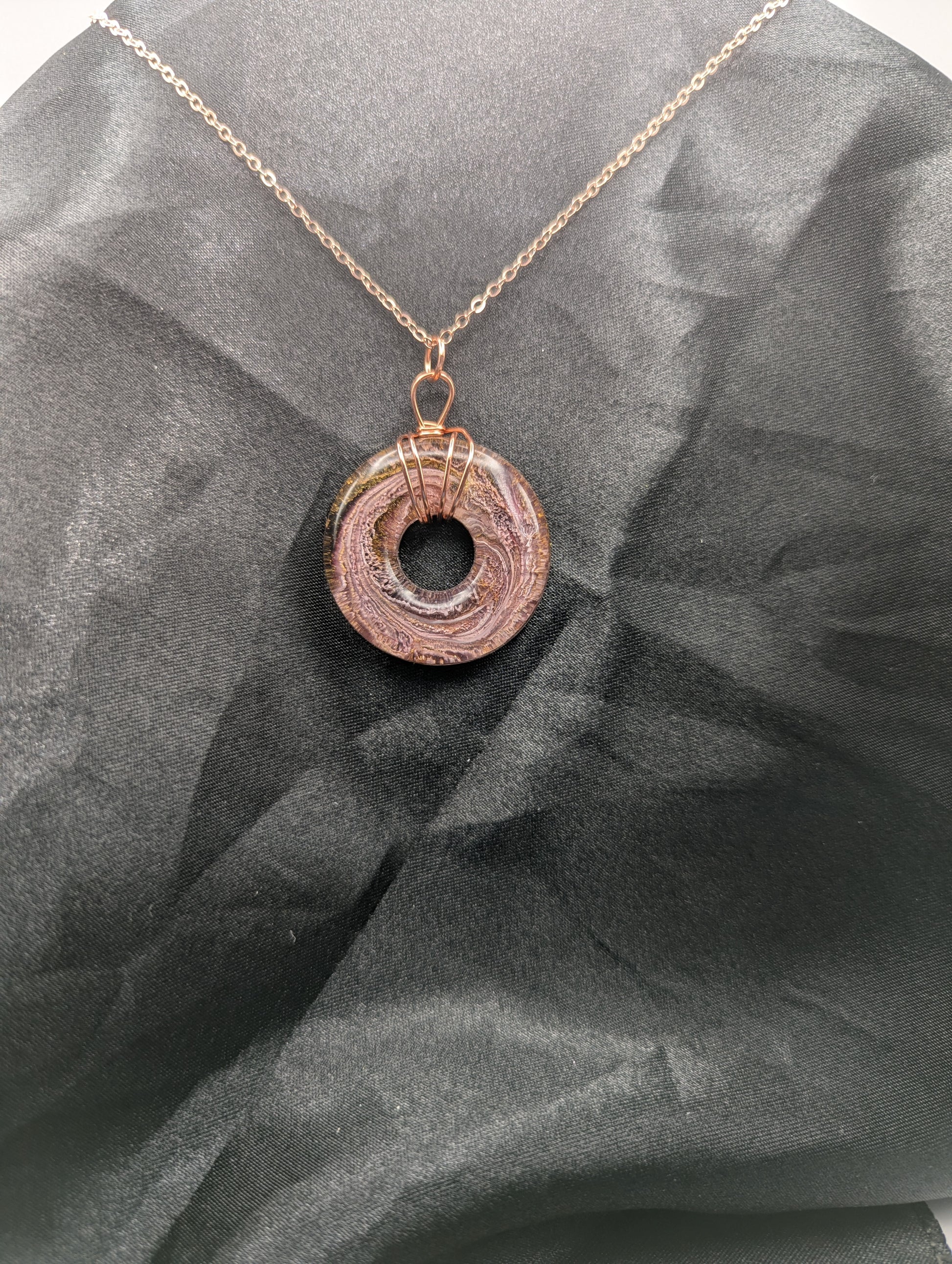 Wire Wrapped Donut Resin Pendant Necklace - Petri Effect with shades of pink & purple swirls. Resin Necklace on a rose gold colored stainless steel plated metal chain.