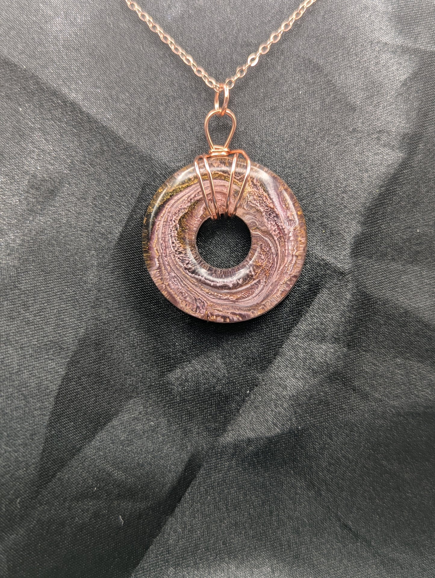 Wire Wrapped Donut Resin Pendant Necklace - Petri Effect with shades of pink & purple swirls. Resin Necklace on a rose gold colored stainless steel plated metal chain.