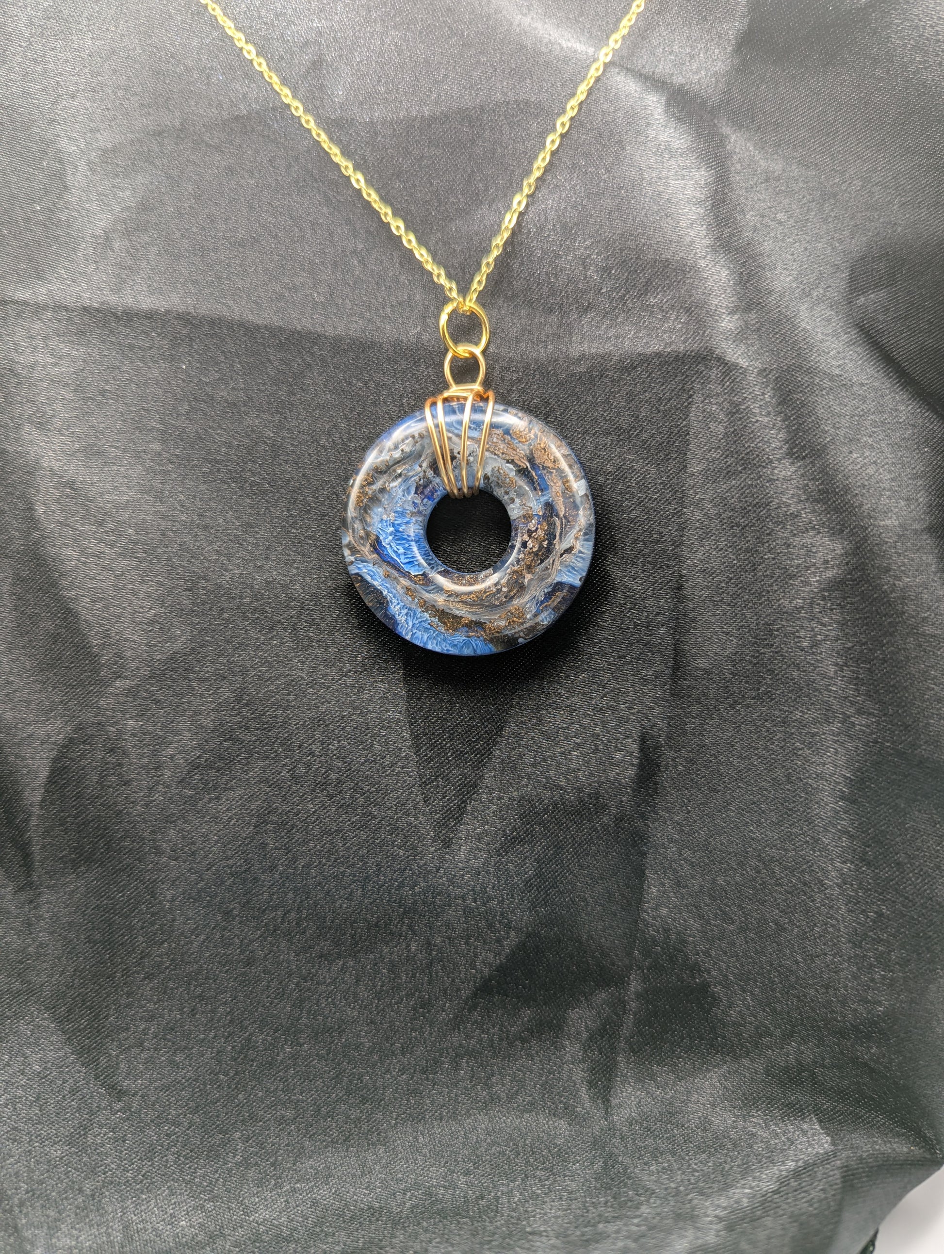 Wire Wrapped Donut Resin Pendant Necklace - Petri Effect with shades of blue & bronze swirls. Resin Necklace on a gold plated metal chain.