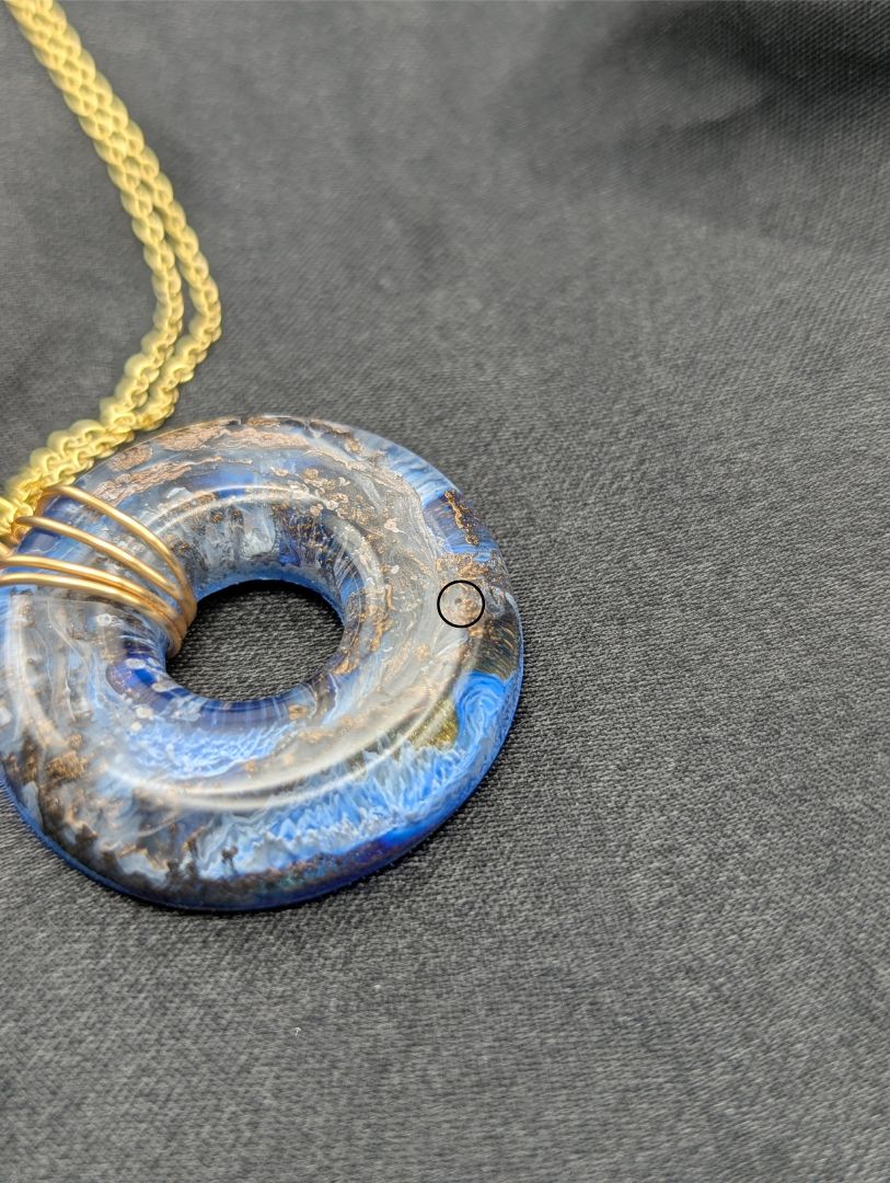 Wire Wrapped Donut Resin Pendant Necklace - Petri Effect with shades of blue & bronze swirls. Resin Necklace on a gold plated metal chain.