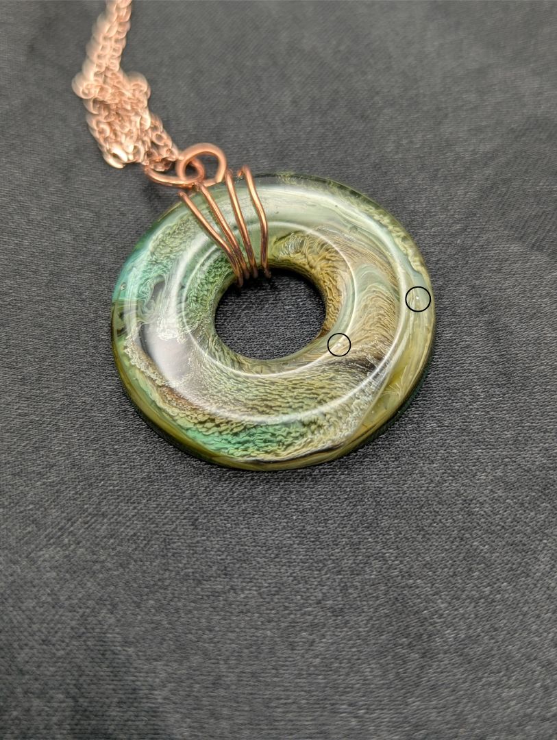 Wire Wrapped Donut Resin Pendant Necklace - Petri Effect with shades of green, yellow, & brown swirls. Resin Necklace on a rose gold colored stainless steel plated metal chain.