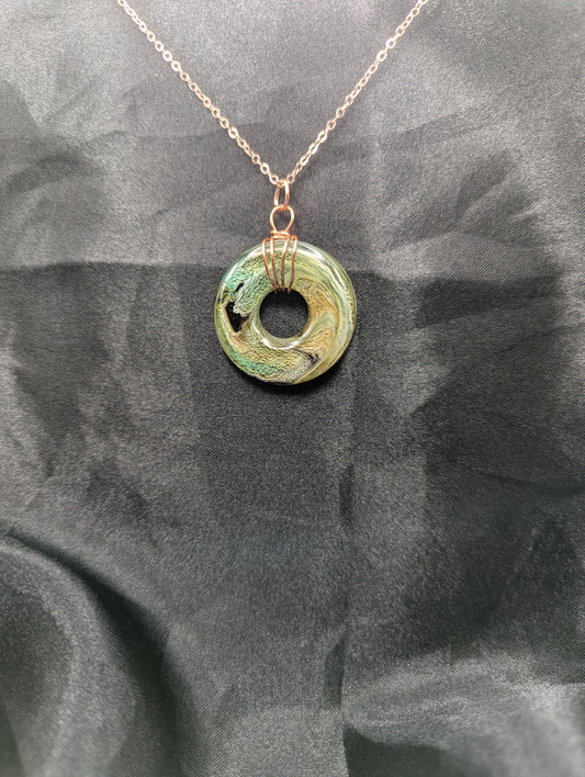 Wire Wrapped Donut Resin Pendant Necklace - Petri Effect with shades of green, yellow, & brown swirls. Resin Necklace on a rose gold colored stainless steel plated metal chain.