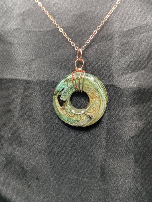 Wire Wrapped Donut Resin Pendant Necklace - Petri Effect with shades of green, yellow, & brown swirls. Resin Necklace on a rose gold colored stainless steel plated metal chain.