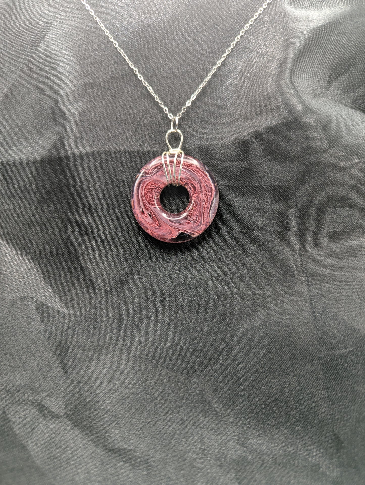 Wire Wrapped Donut Resin Pendant Necklace - Petri Effect with shades of red, pink, & black swirls. Resin Necklace on a stainless steel chain.