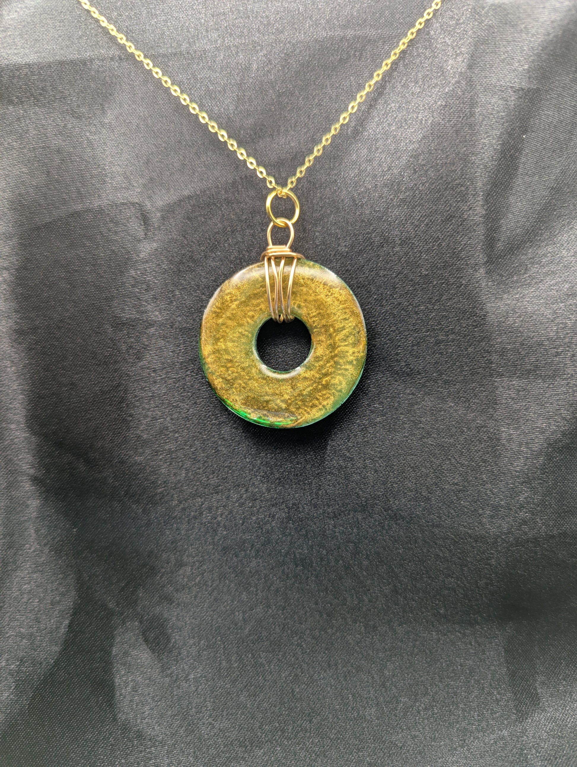 Back view of Wire Wrapped Donut Resin Pendant Necklace - Petri Effect with shades of green & brass swirls. Resin Necklace on a gold plated metal chain.