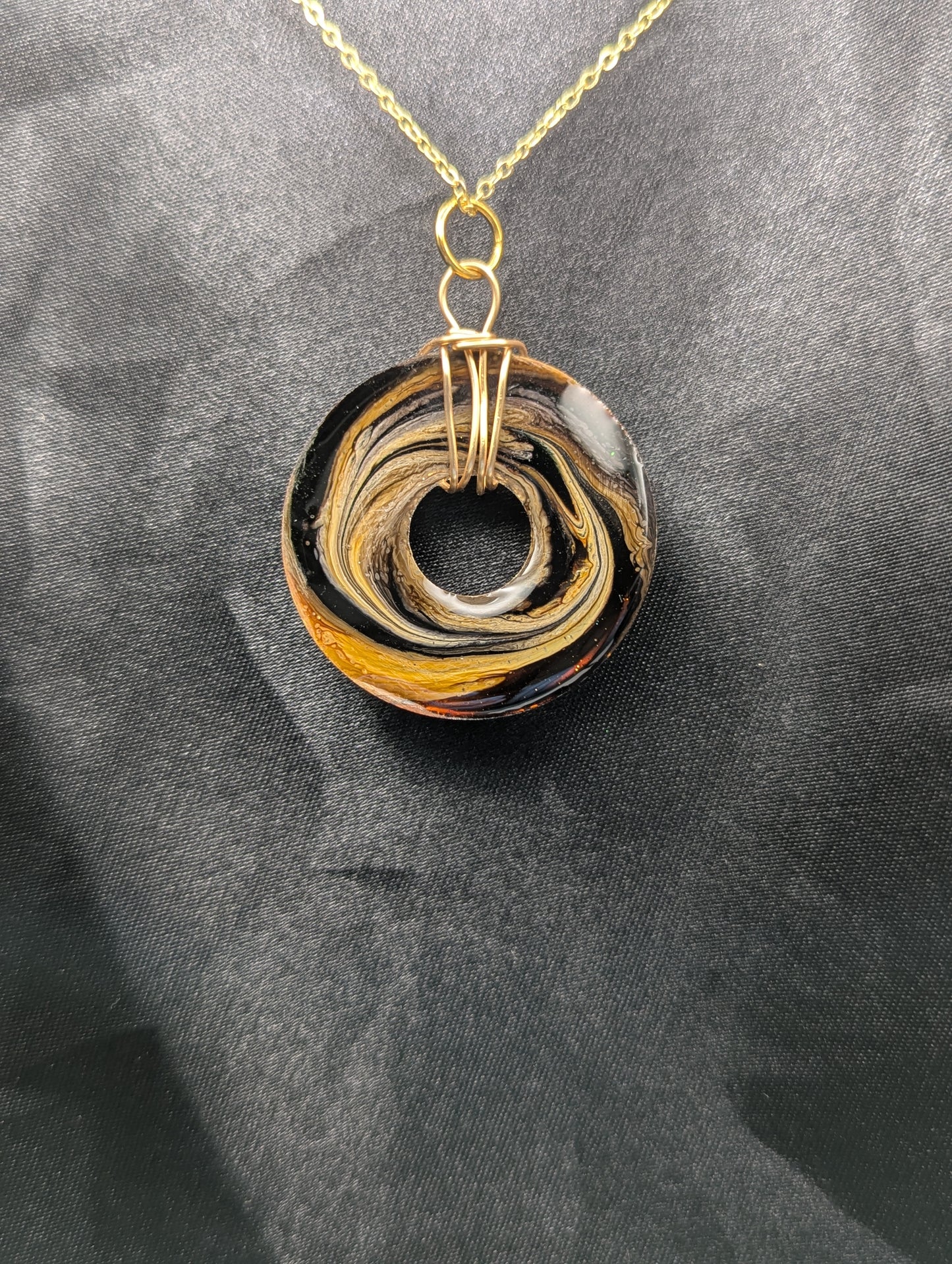 Back view of Wire Wrapped Donut Resin Pendant Necklace - Petri Effect with shades of brown & yellow swirls. Resin Necklace on a gold plated metal chain.