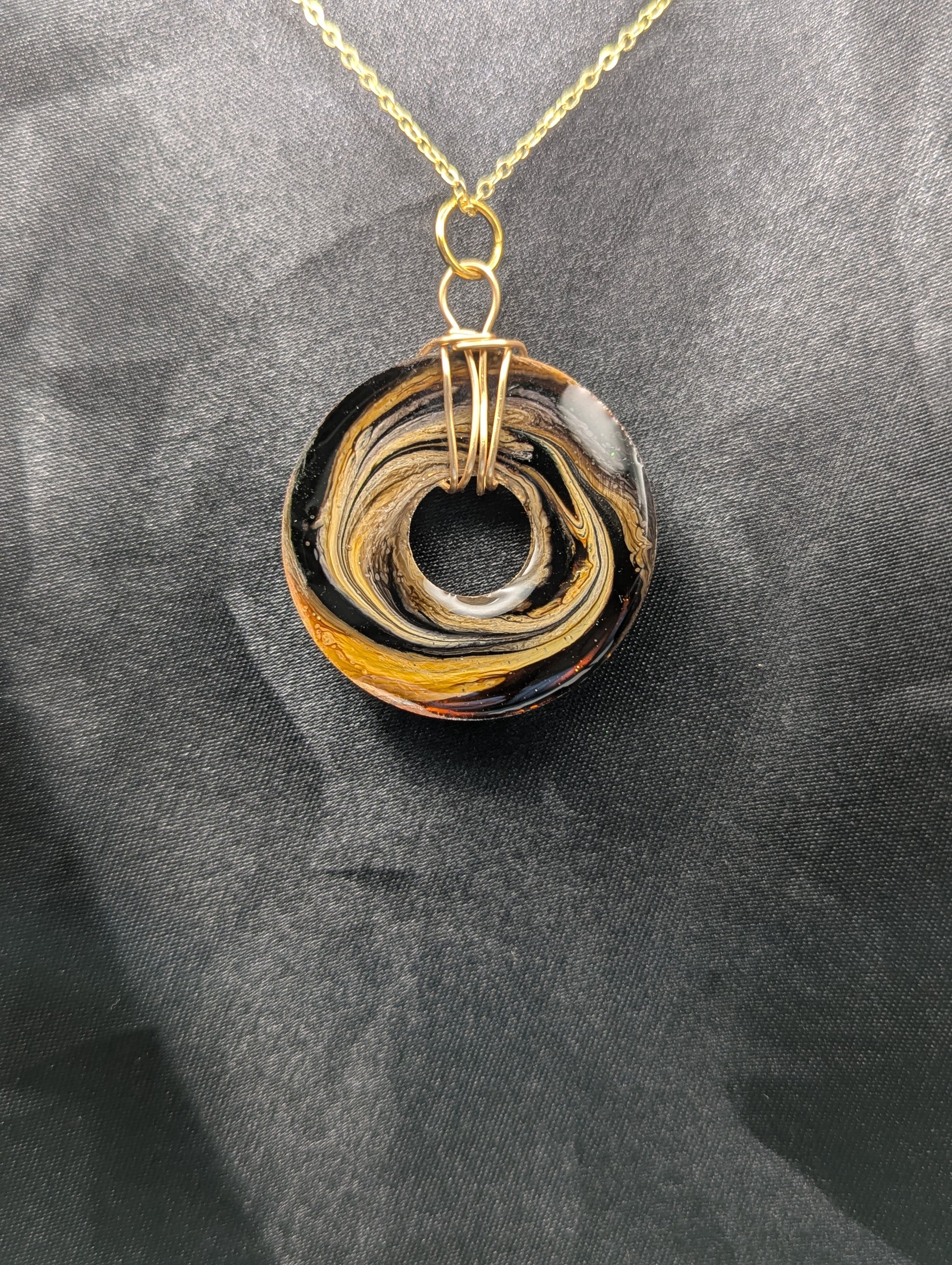 Back view of Wire Wrapped Donut Resin Pendant Necklace - Petri Effect with shades of brown & yellow swirls. Resin Necklace on a gold plated metal chain.