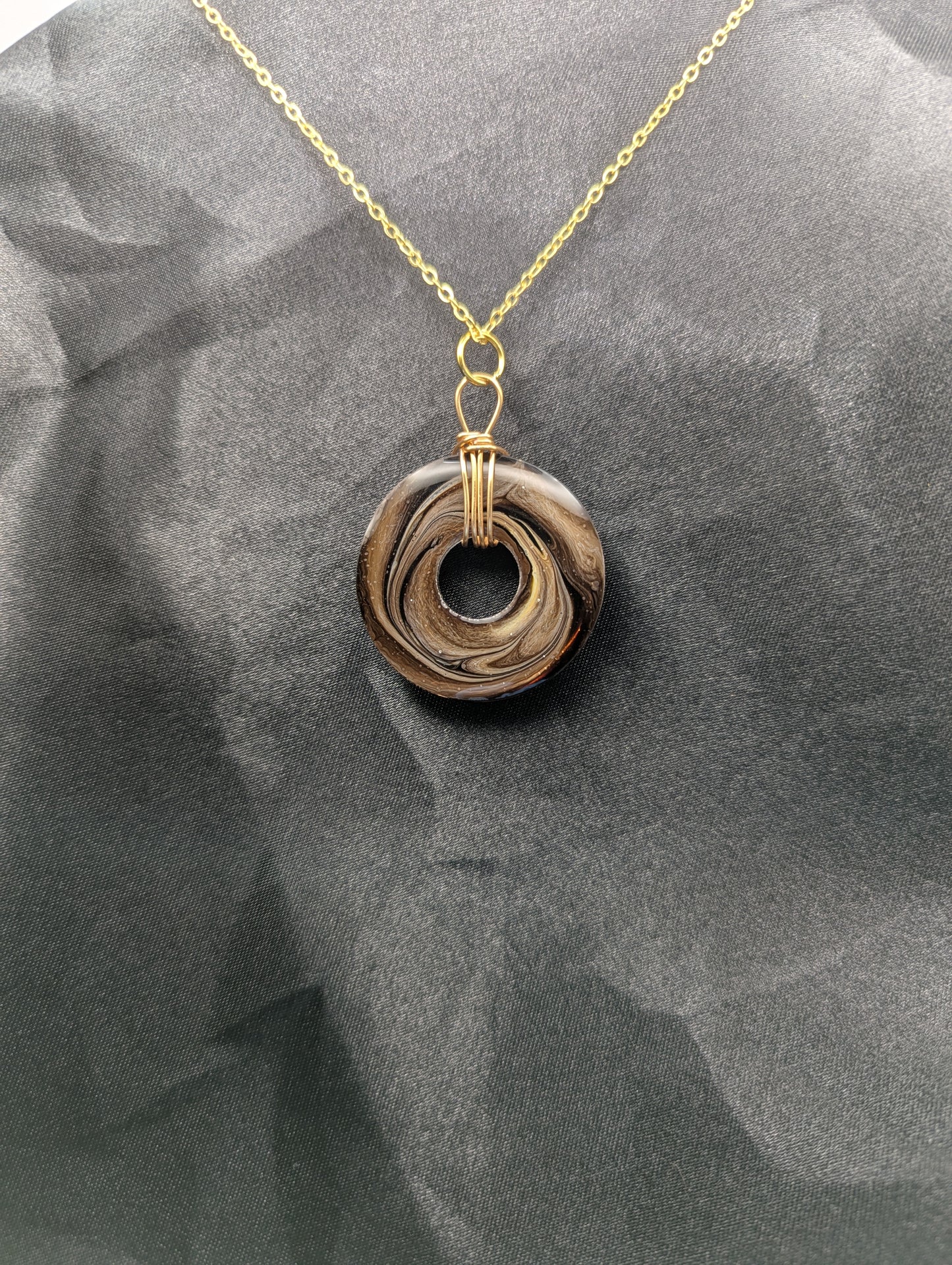 Back view of Wire Wrapped Donut Resin Pendant Necklace - Petri Effect with shades of brown swirls. Resin Necklace on a gold plated metal chain