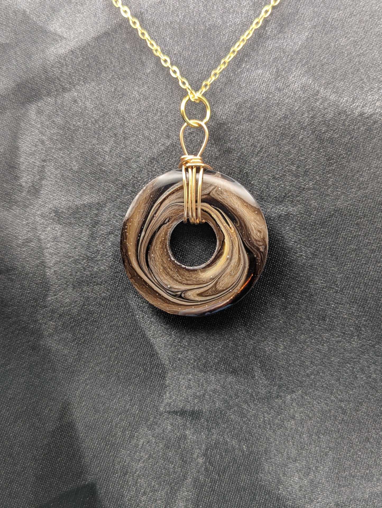 Back view of Wire Wrapped Donut Resin Pendant Necklace - Petri Effect with shades of brown swirls. Resin Necklace on a gold plated metal chain
