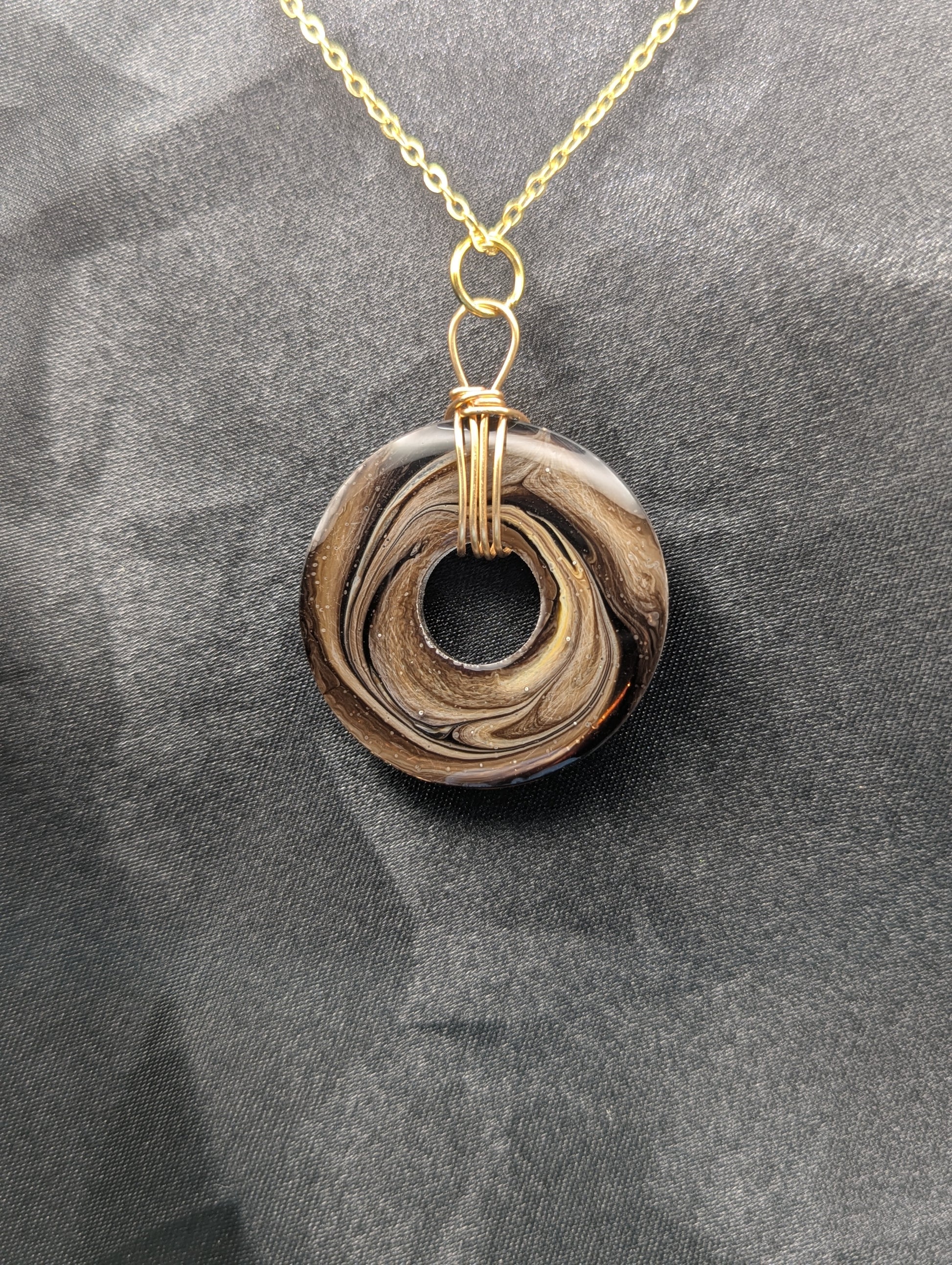 Back view of Wire Wrapped Donut Resin Pendant Necklace - Petri Effect with shades of brown swirls. Resin Necklace on a gold plated metal chain