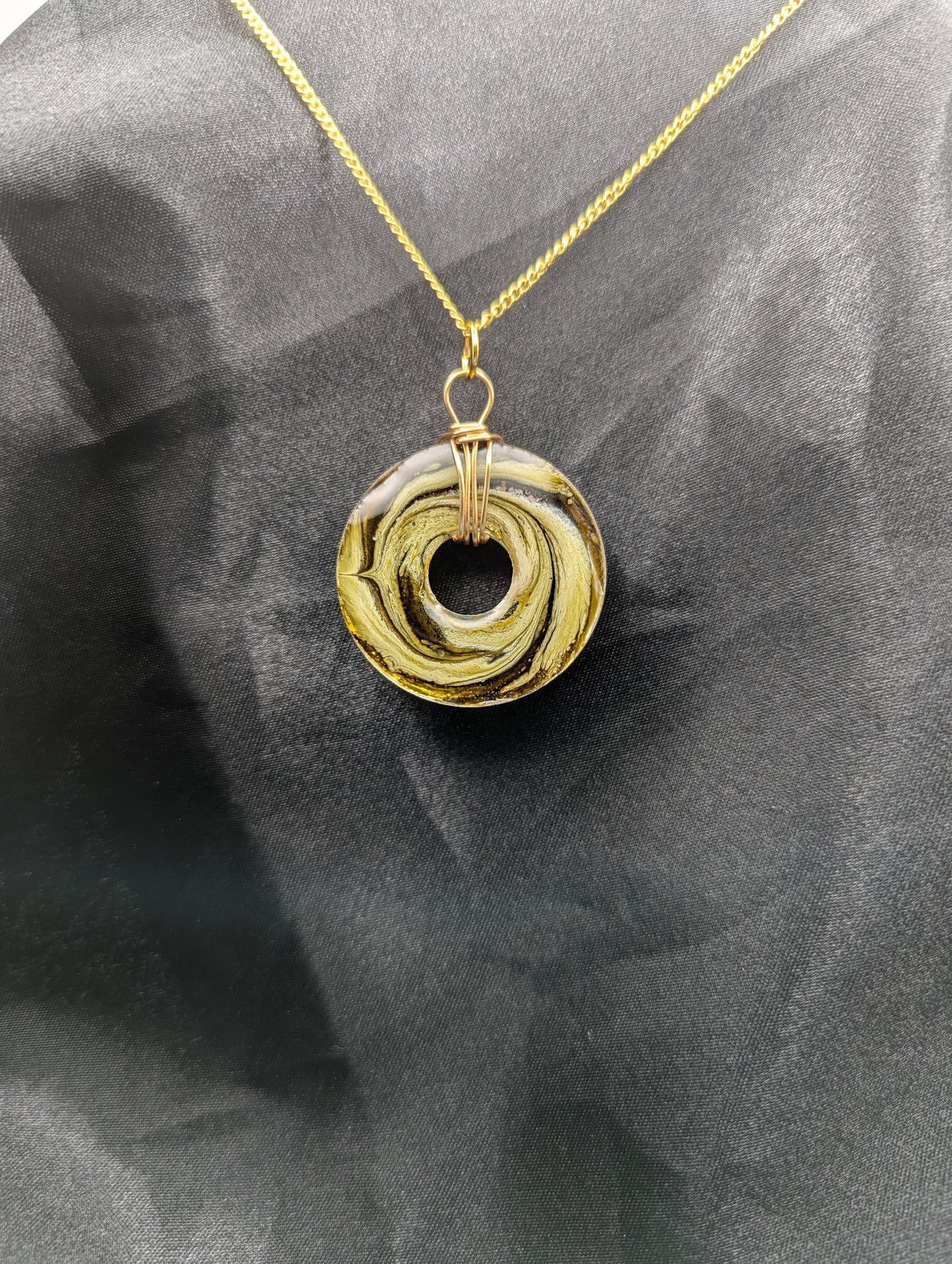 Back view of Wire Wrapped Donut Resin Pendant Necklace - Petri Effect with shades of light yellow & light green swirls. Resin Necklace on a gold plated metal chain.