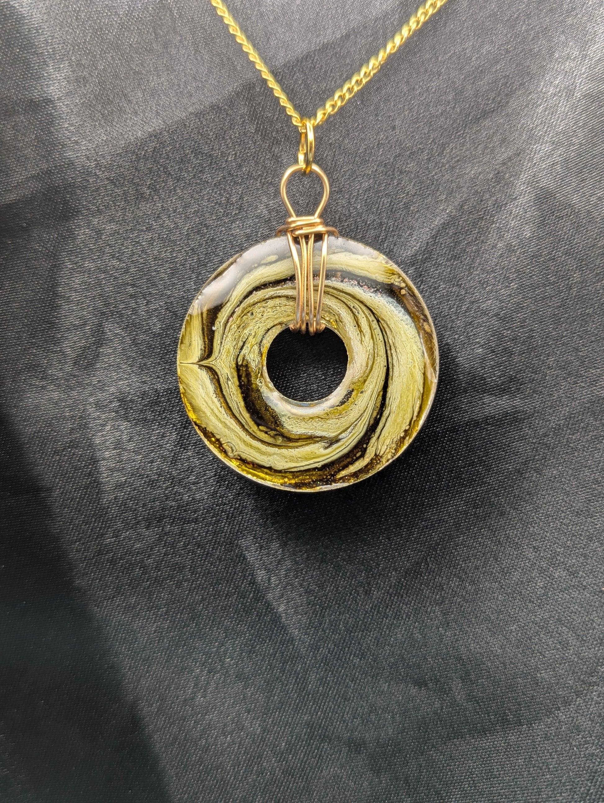 Back view of Wire Wrapped Donut Resin Pendant Necklace - Petri Effect with shades of light yellow & light green swirls. Resin Necklace on a gold plated metal chain.