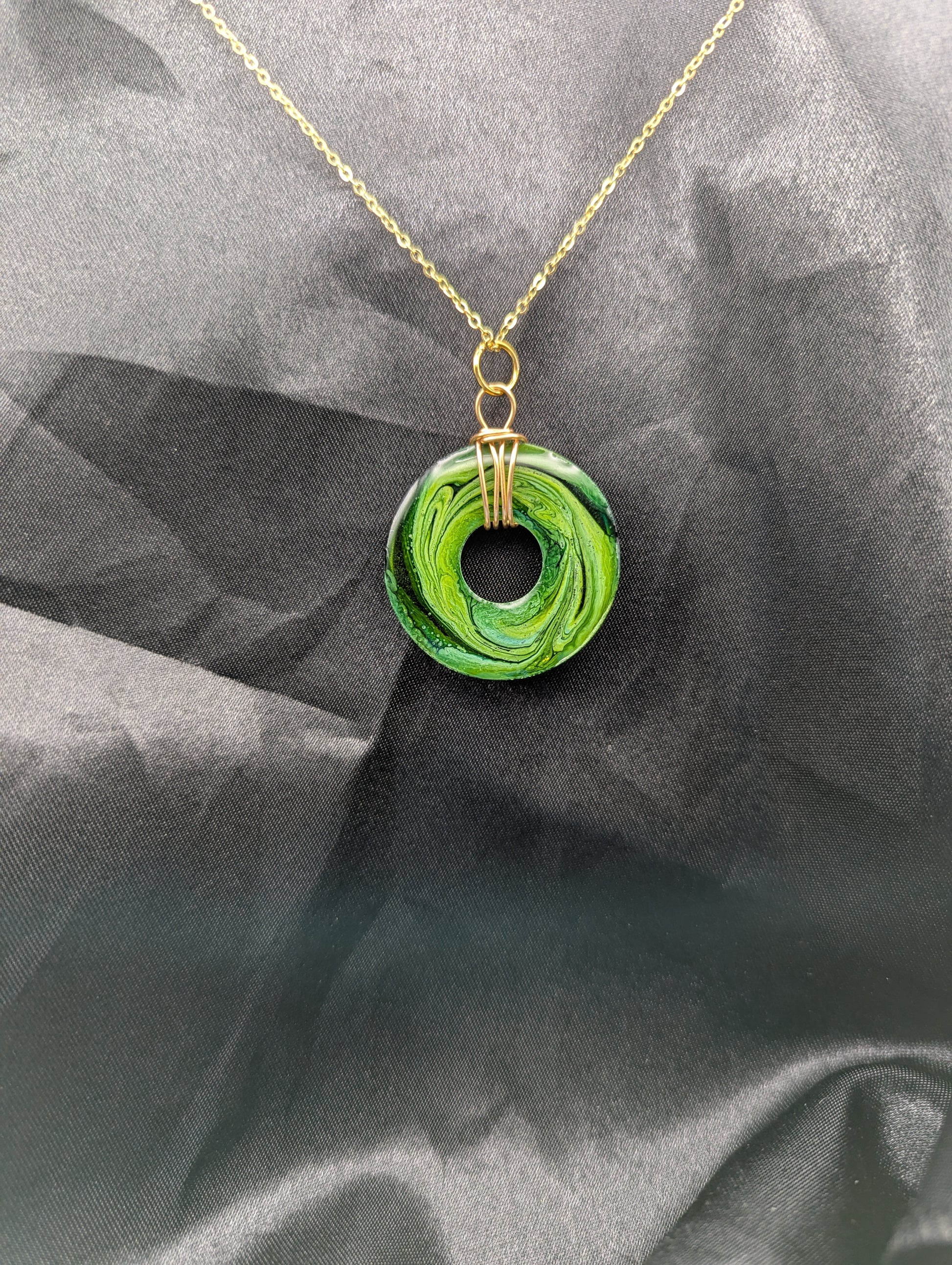 Back view of Wire Wrapped Donut Resin Pendant Necklace - Petri Effect with shades of green swirls. Resin Necklace on a gold plated metal chain.