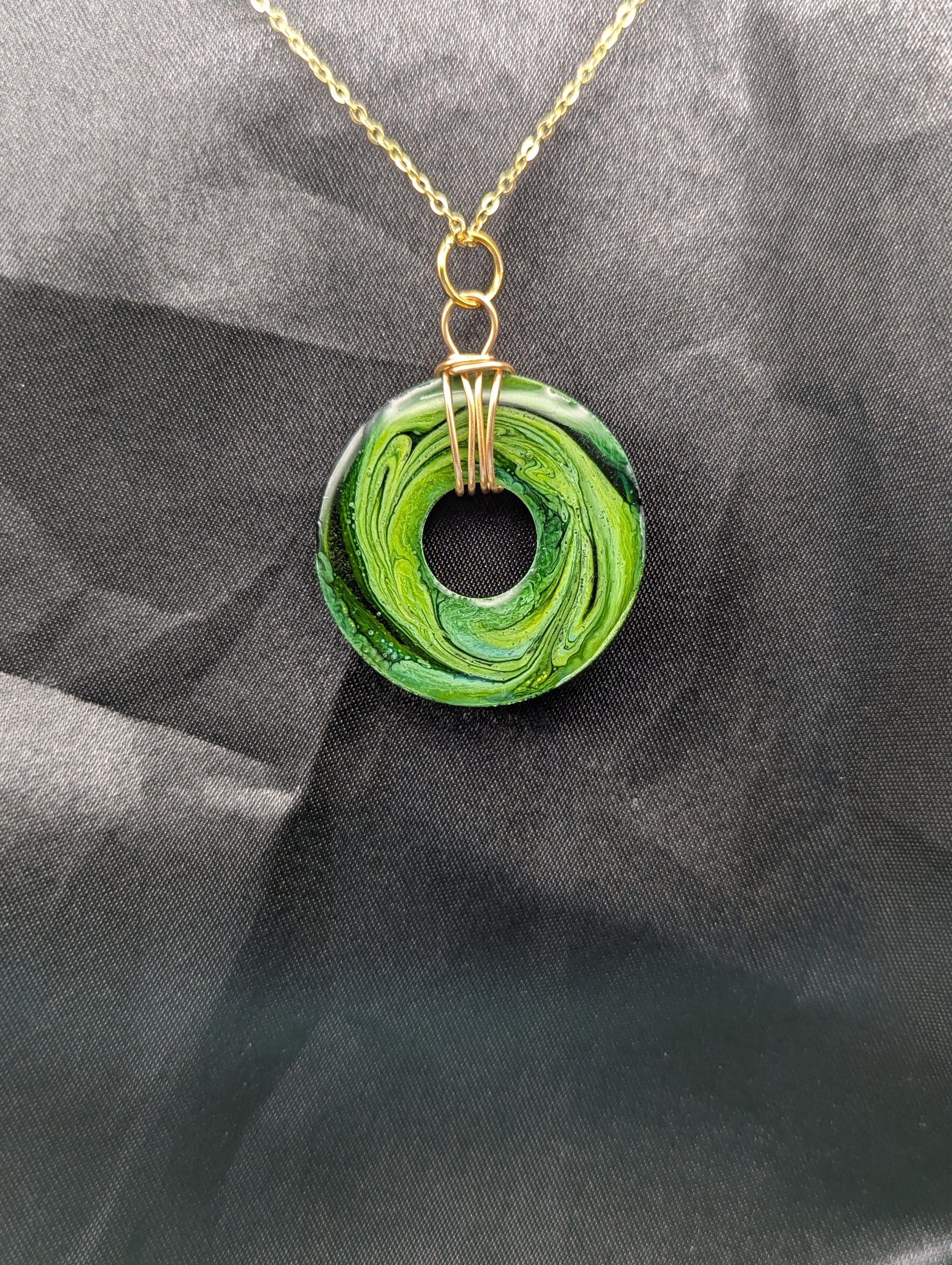 Back view of Wire Wrapped Donut Resin Pendant Necklace - Petri Effect with shades of green swirls. Resin Necklace on a gold plated metal chain.