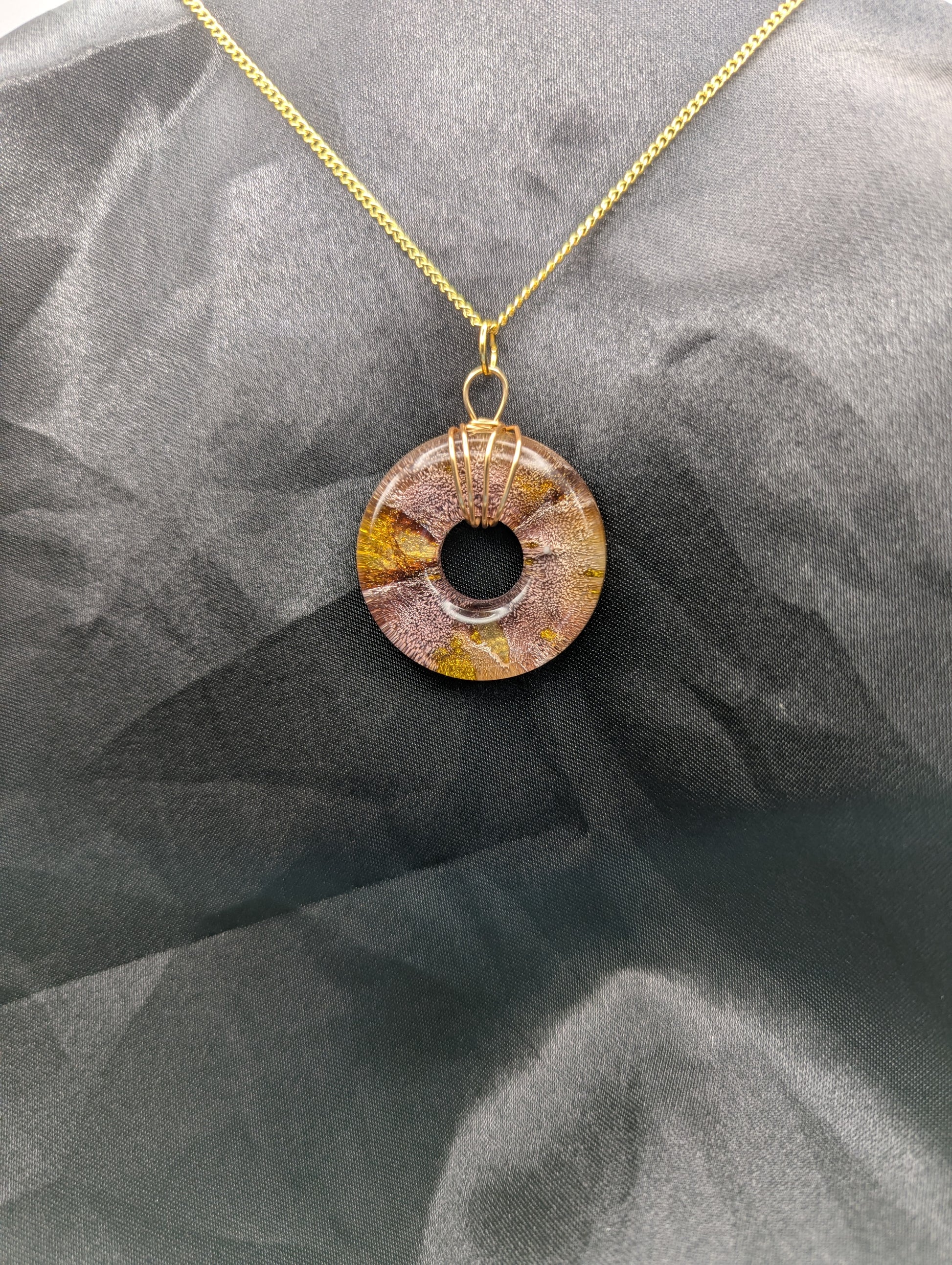 Wire Wrapped Donut Resin Pendant Necklace - Petri Effect with shades of red & gold swirls. Resin Necklace on a gold plated metal chain.