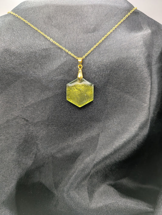 Yellow Hexagon Pendant Necklace with a color shifting background. Resin pendant on a gold pinch bail & gold plated metal chain.