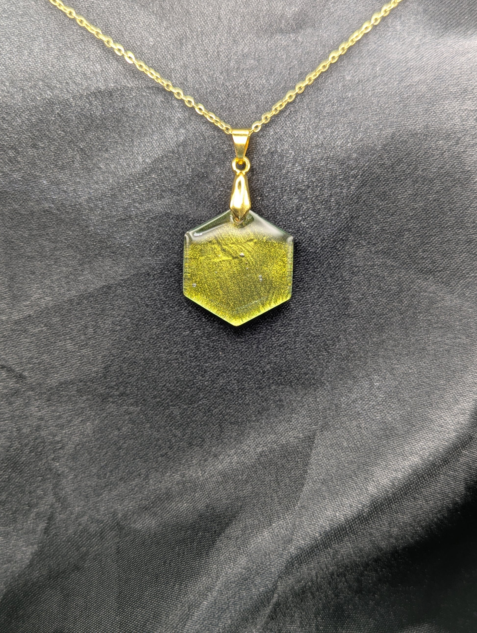Yellow Hexagon Pendant Necklace with a color shifting background. Resin pendant on a gold pinch bail & gold plated metal chain.