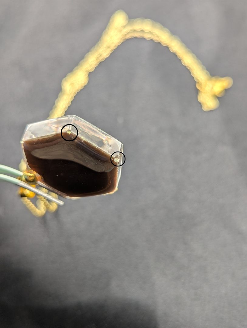Yellow Hexagon Pendant Necklace with a color shifting background. Resin pendant on a gold pinch bail & gold plated metal chain.