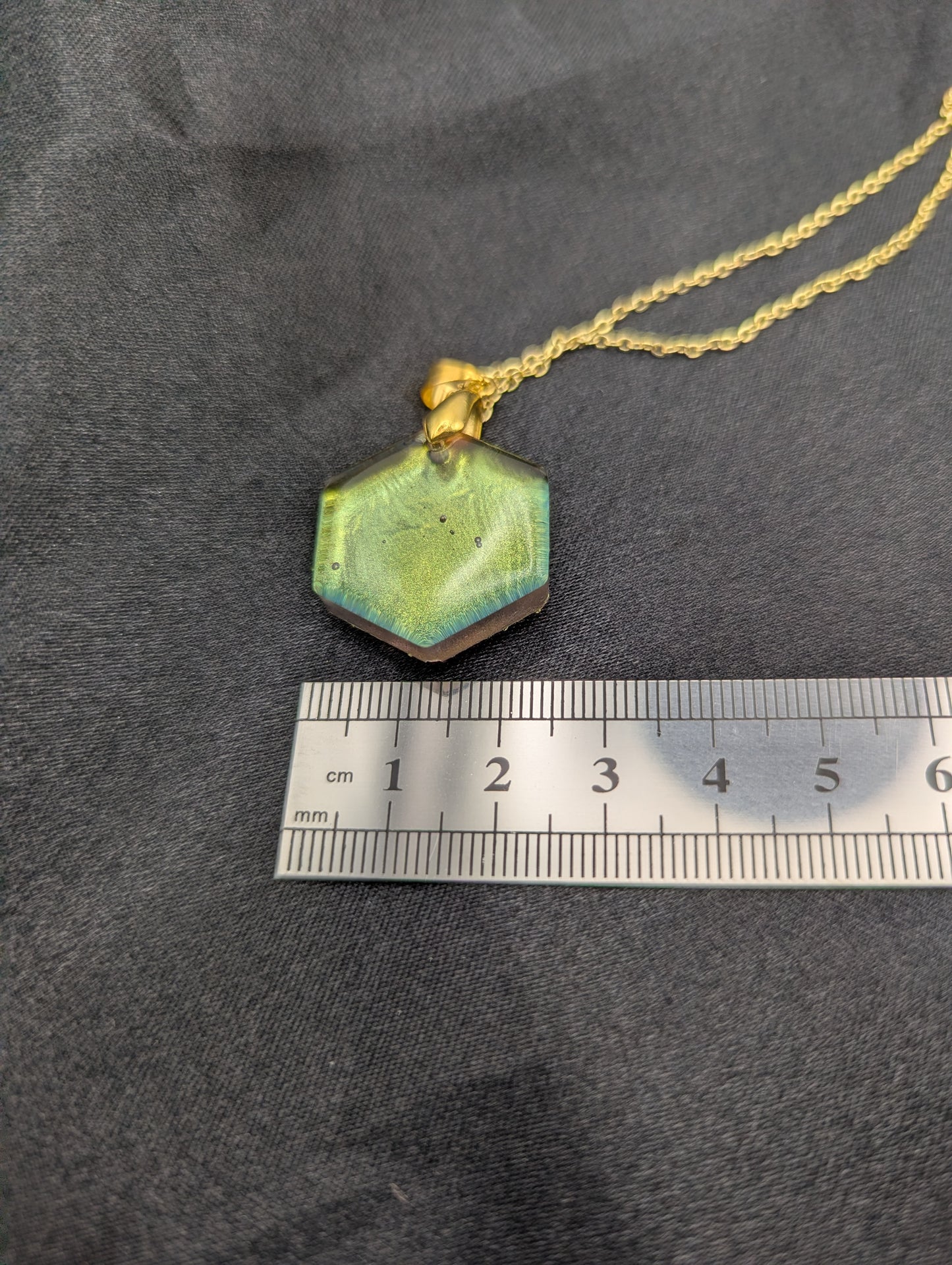 Size example pic of pendant size in centimeters, showing pendant is about 2.5 cm wide.