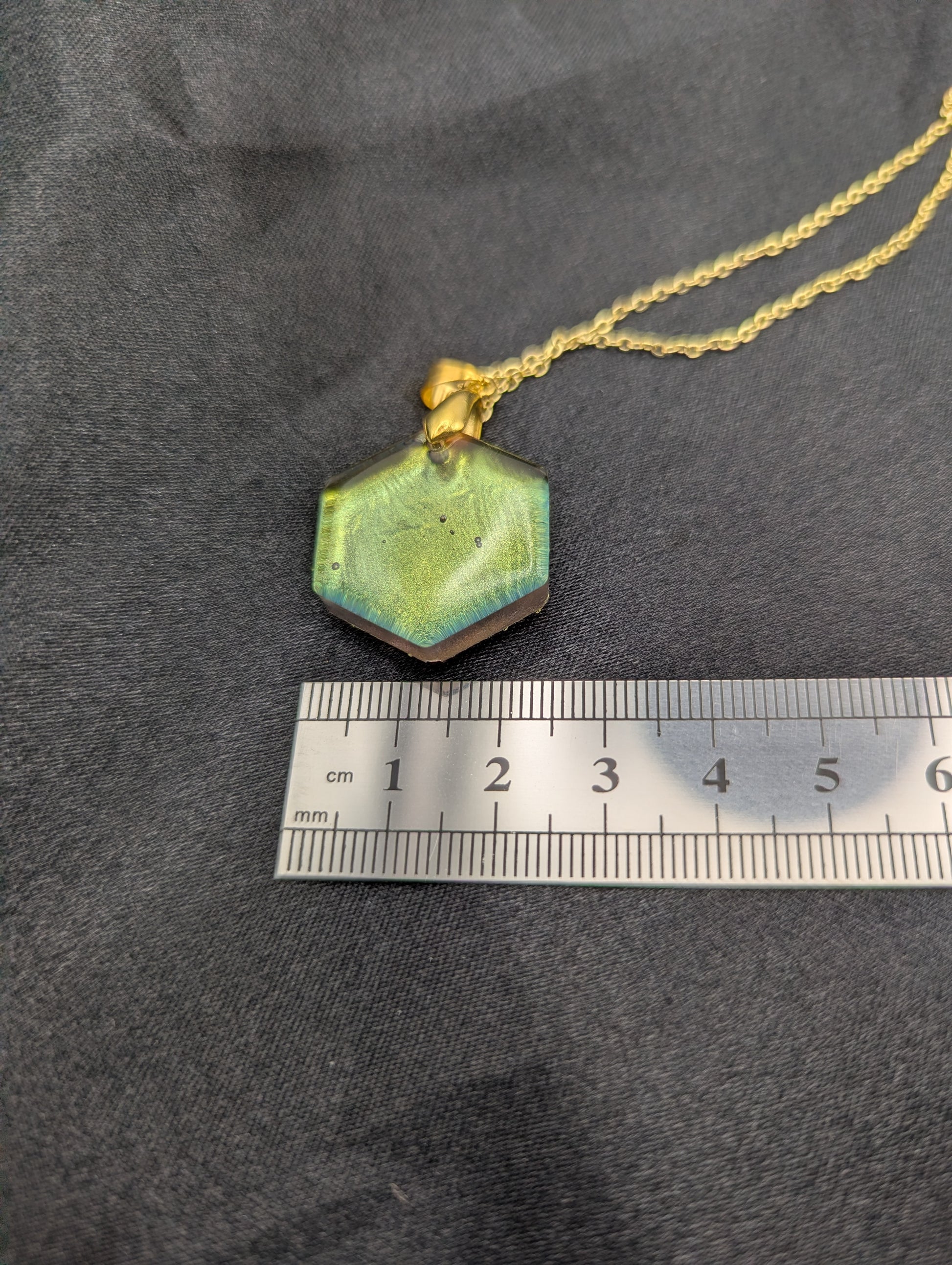 Size example pic of pendant size in centimeters, showing pendant is about 2.5 cm wide.