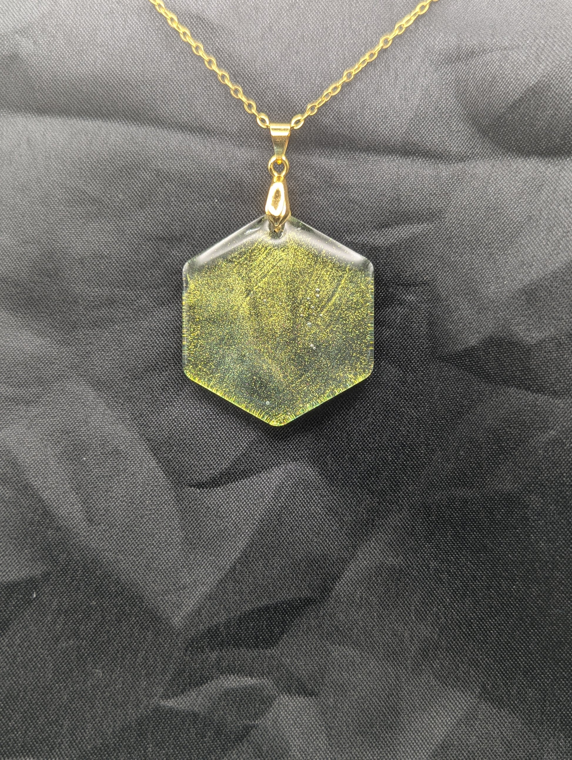 Color Shifting Hexagon Resin Pendant Necklace on a gold plated metal chain.