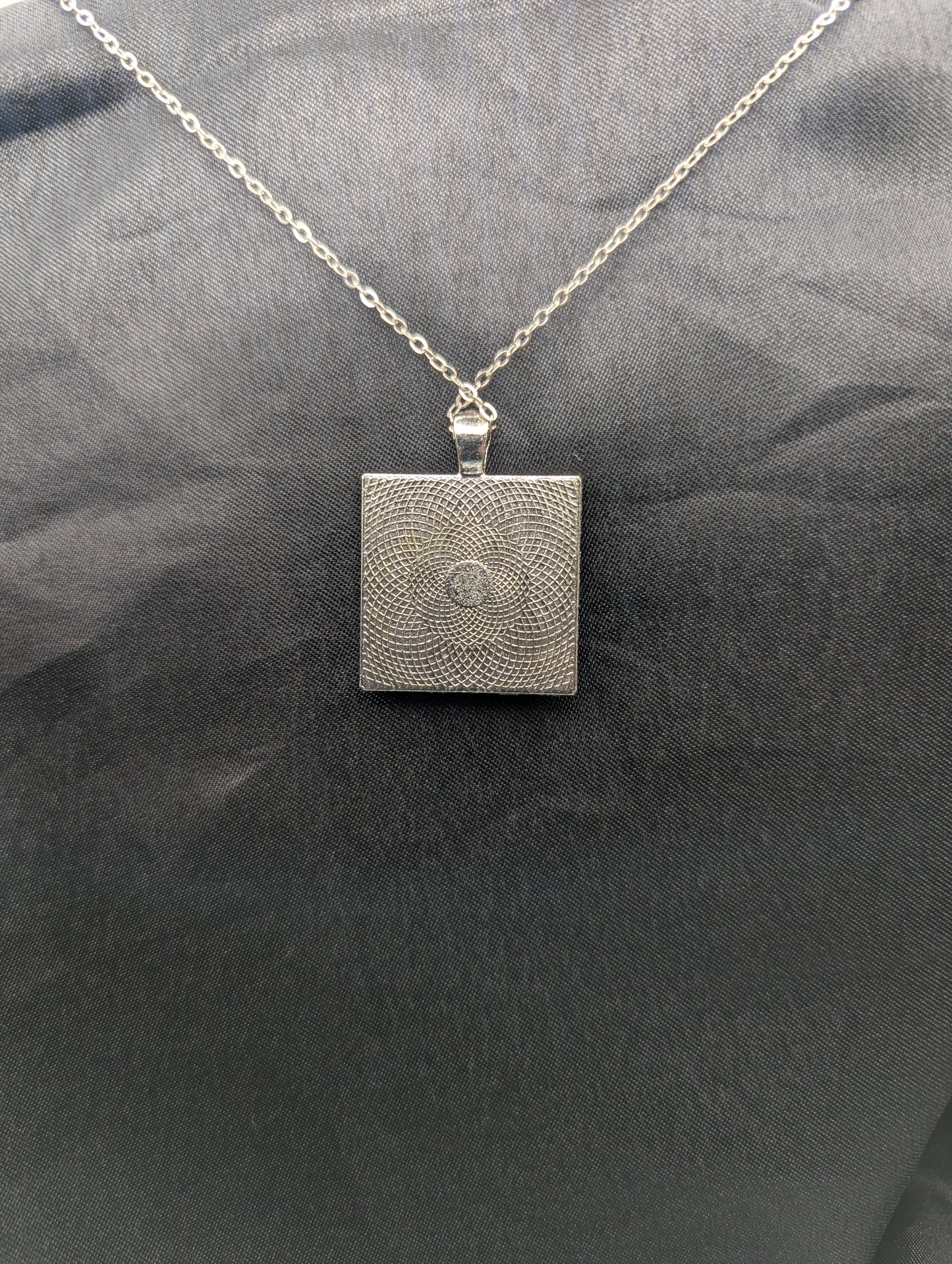 Back view of silver square bezel pendant necklace on a stainless steel chain.