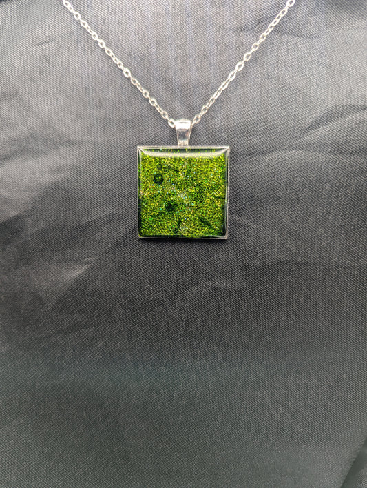 Silver square bezel filled with sparkly green resin. Resin pendant necklace on a stainless steel chain.