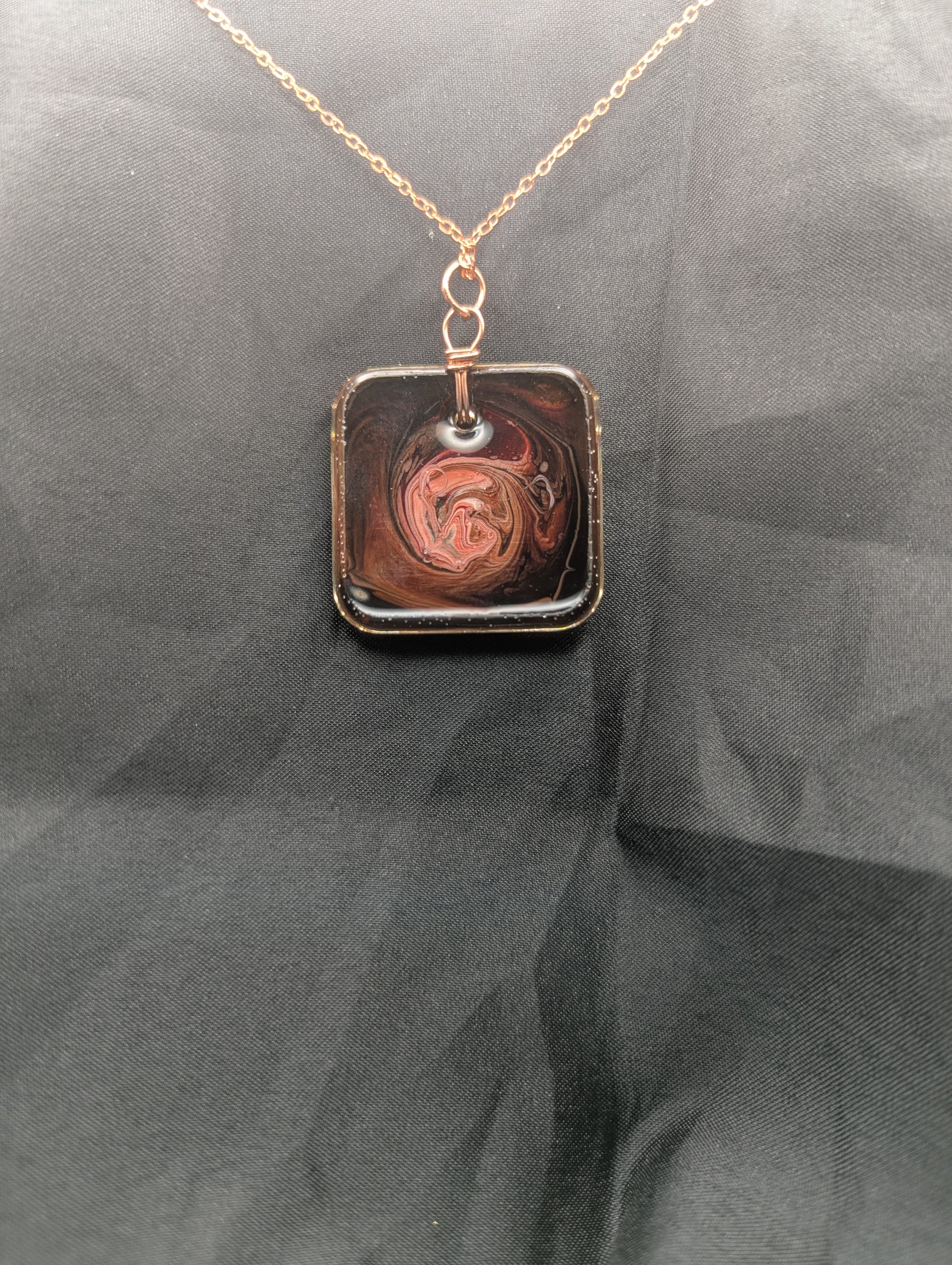 Back view of Red & Brown Swirl Square Pendant wrapped in a solid copper wire on a rose gold colored stainless steel plated metal chain. Resin Square Jewelry Pendant with Petri Effect.