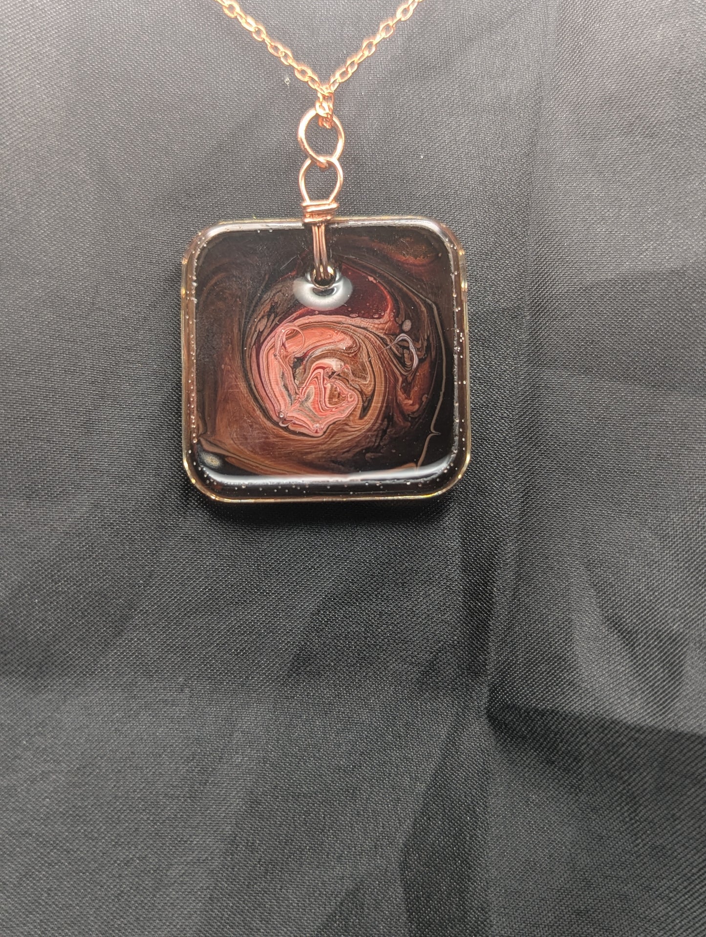 Back view of Red & Brown Swirl Square Pendant wrapped in a solid copper wire on a rose gold colored stainless steel plated metal chain. Resin Square Jewelry Pendant with Petri Effect.