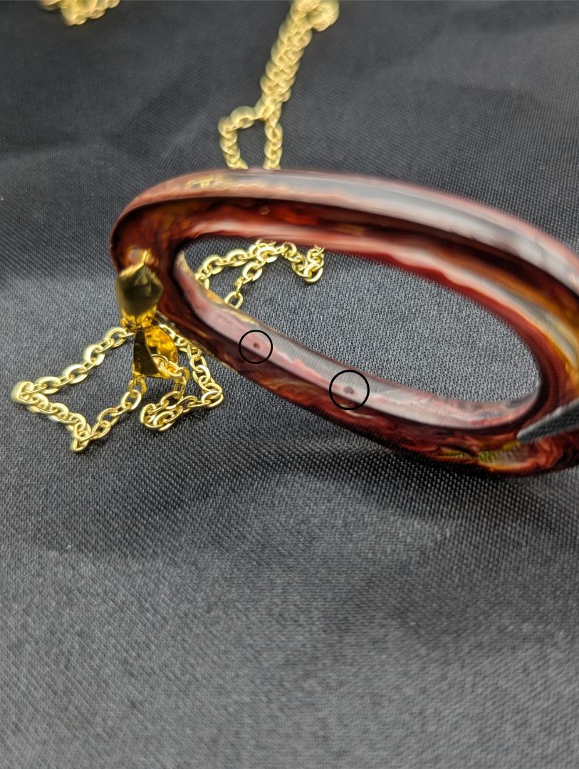 Pink & orange Zero Shaped Resin Pendant Necklace - Petri Effect with shades of pink, orange, & red swirls. Resin Necklace on a gold pinch bail & gold plated metal chain.