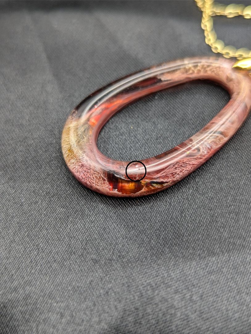 Pink & orange Zero Shaped Resin Pendant Necklace - Petri Effect with shades of pink, orange, & red swirls. Resin Necklace on a gold pinch bail & gold plated metal chain.