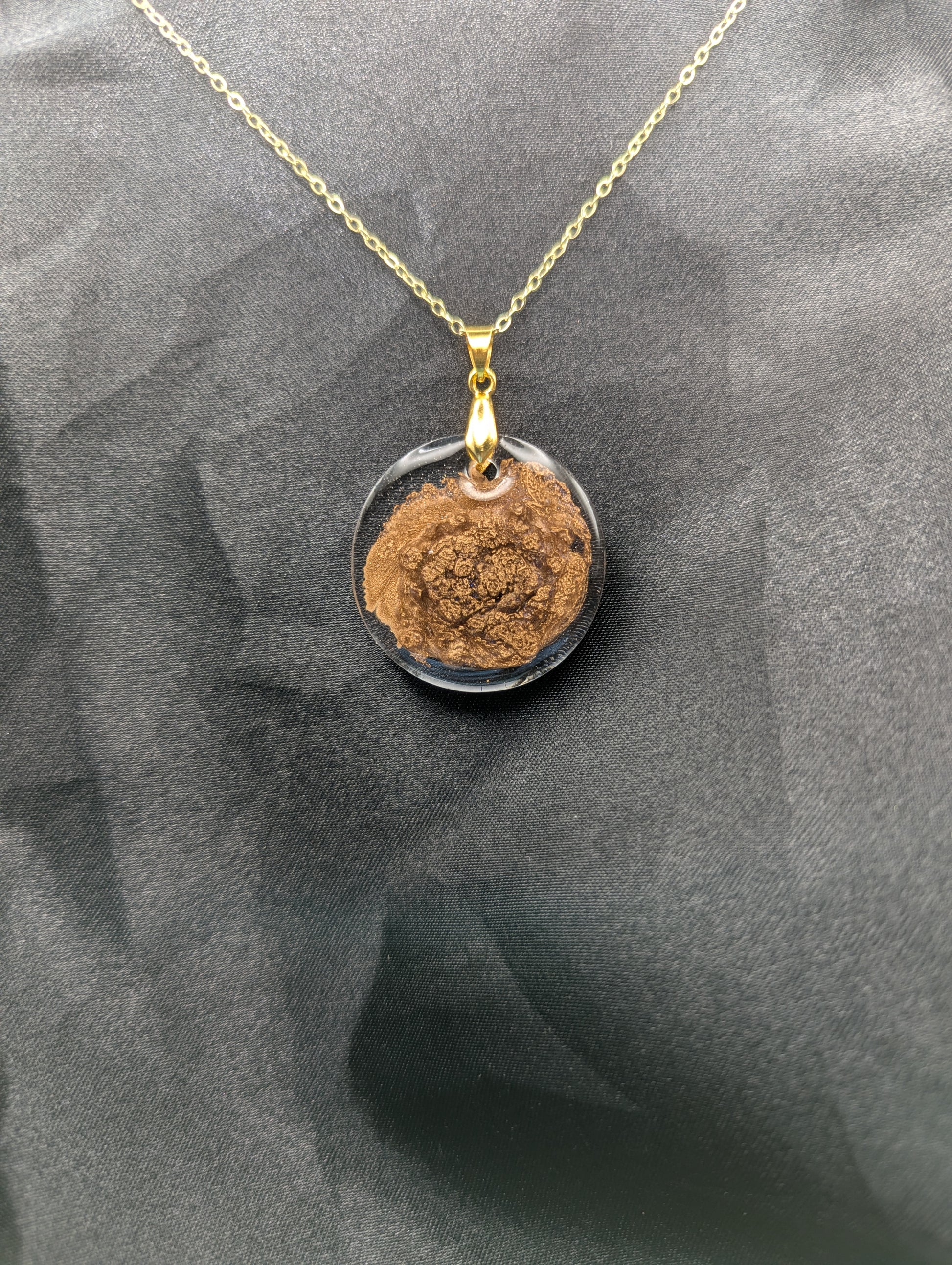 Gold Swirl Circle Resin Pendant with gold pinch bail on a gold plated metal chain.