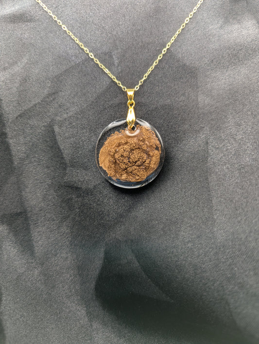 Gold Swirl Circle Resin Pendant with gold pinch bail on a gold plated metal chain.