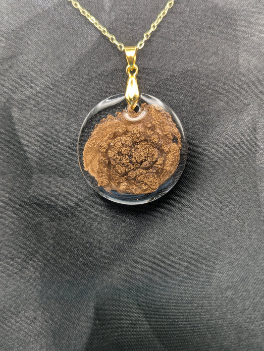 Gold Swirl Circle Resin Pendant with gold pinch bail on a gold plated metal chain.
