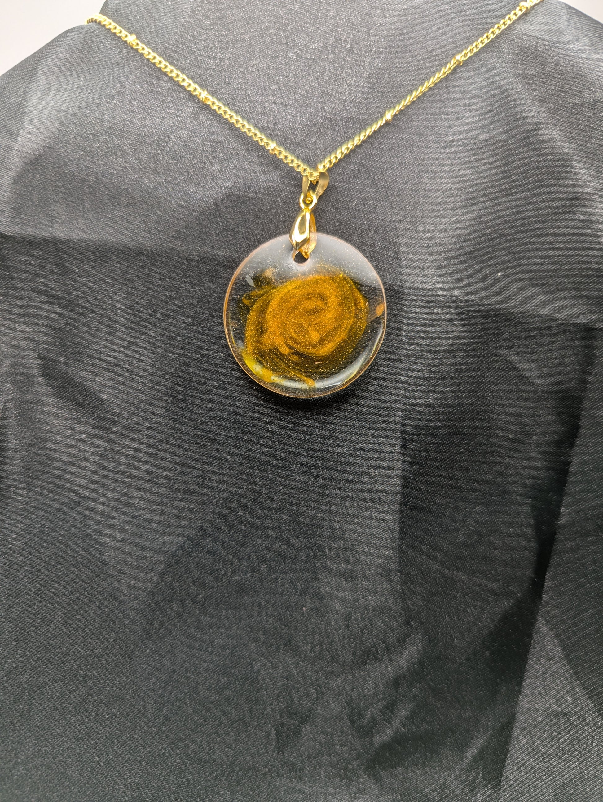 Back view of Yellow & Orange Swirl Circle Resin Pendant with a gold pinch bail on a gold plated metal chain.