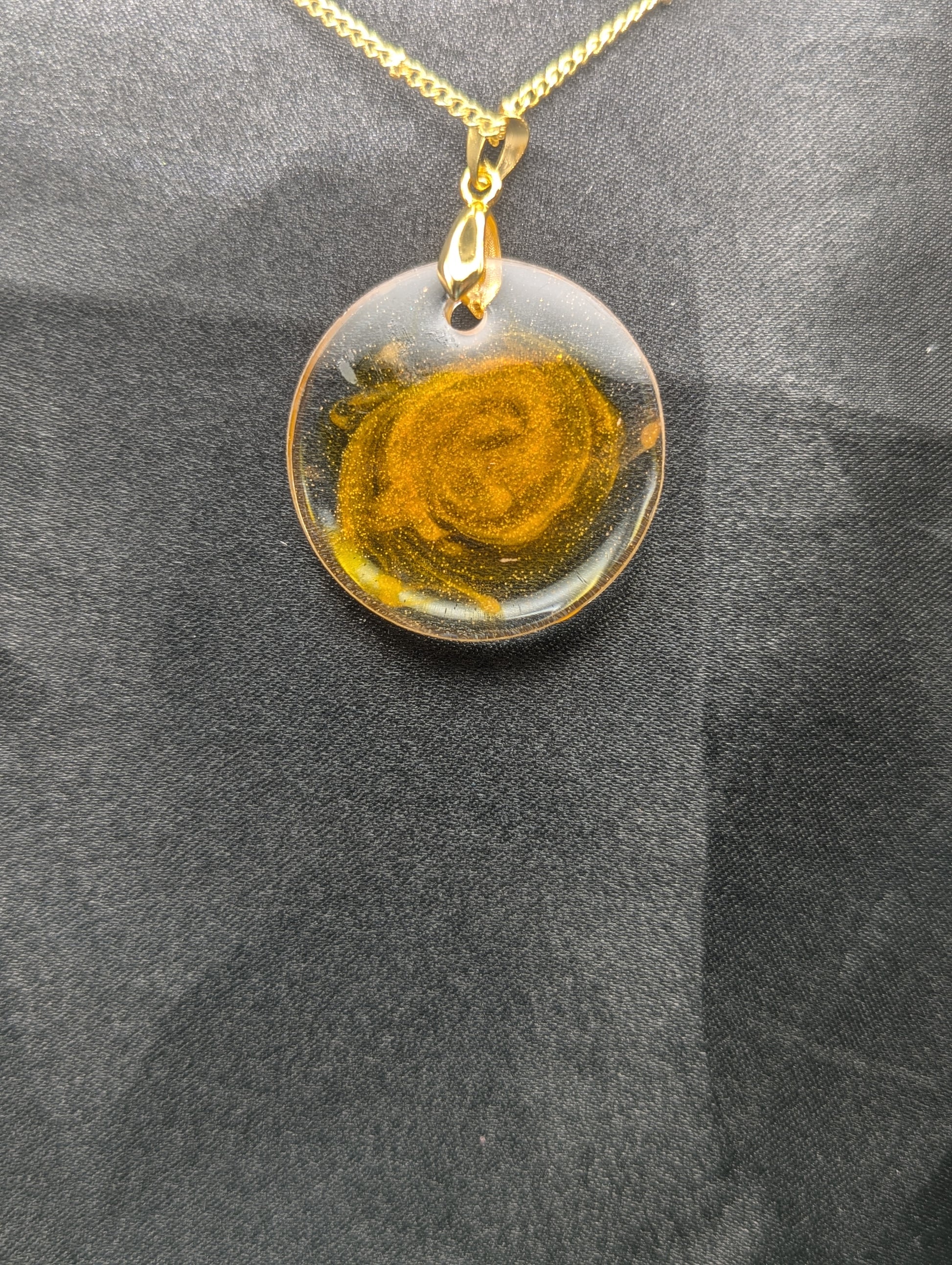 Back view of Yellow & Orange Swirl Circle Resin Pendant with a gold pinch bail on a gold plated metal chain.