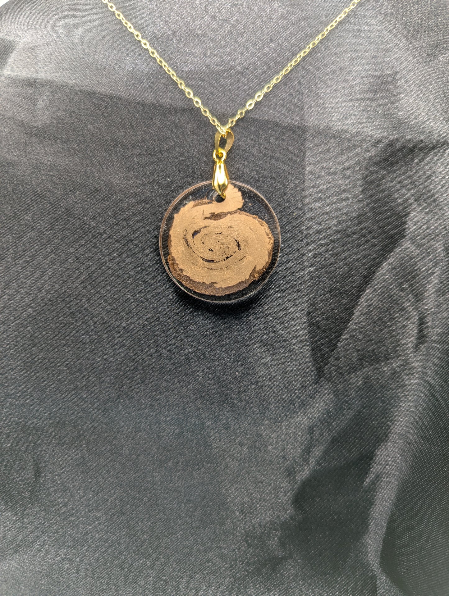 Back view of Gold Swirl Resin Circle pendant on a gold pinch bail and gold plated metal chain.