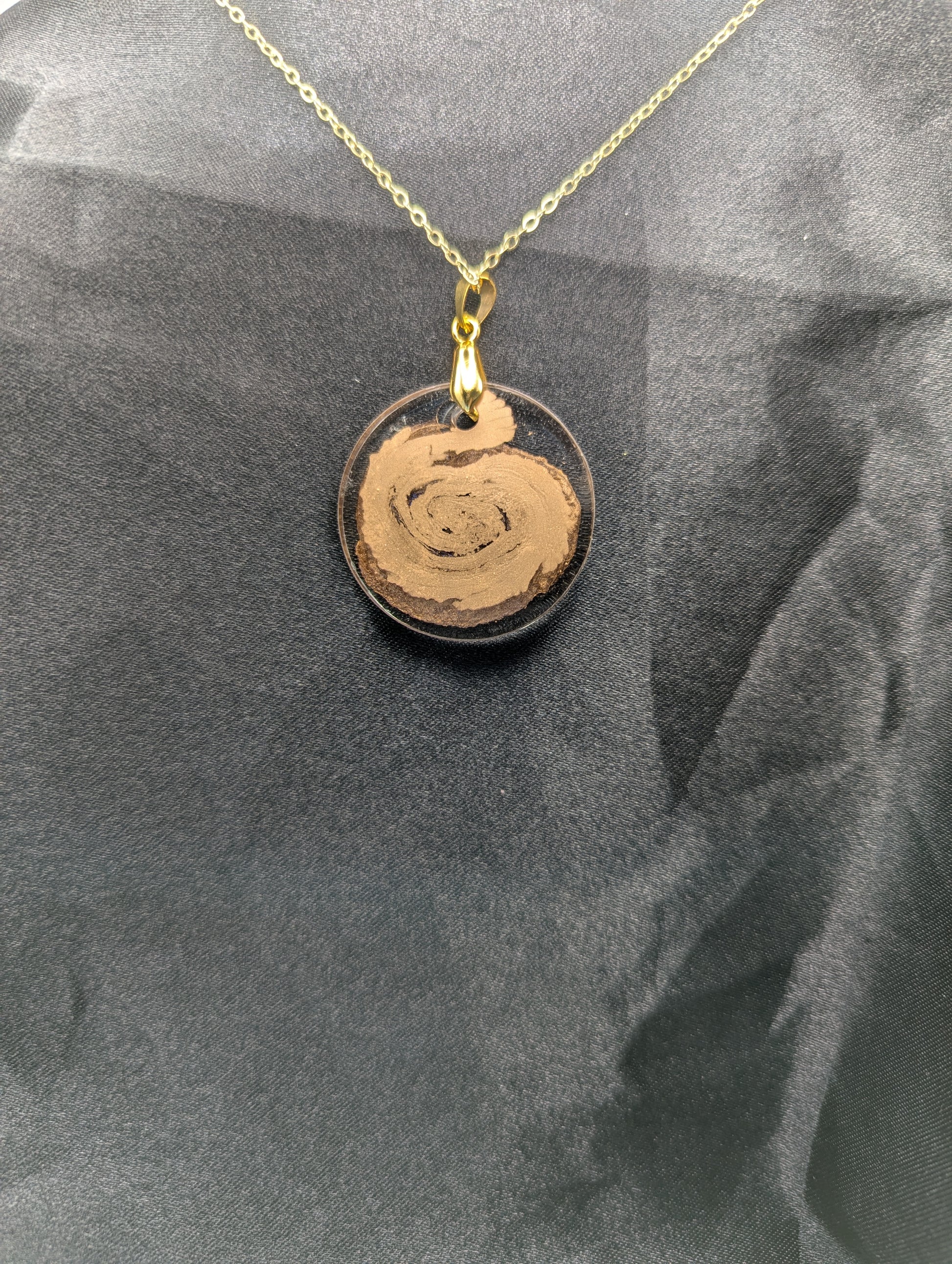 Back view of Gold Swirl Resin Circle pendant on a gold pinch bail and gold plated metal chain.