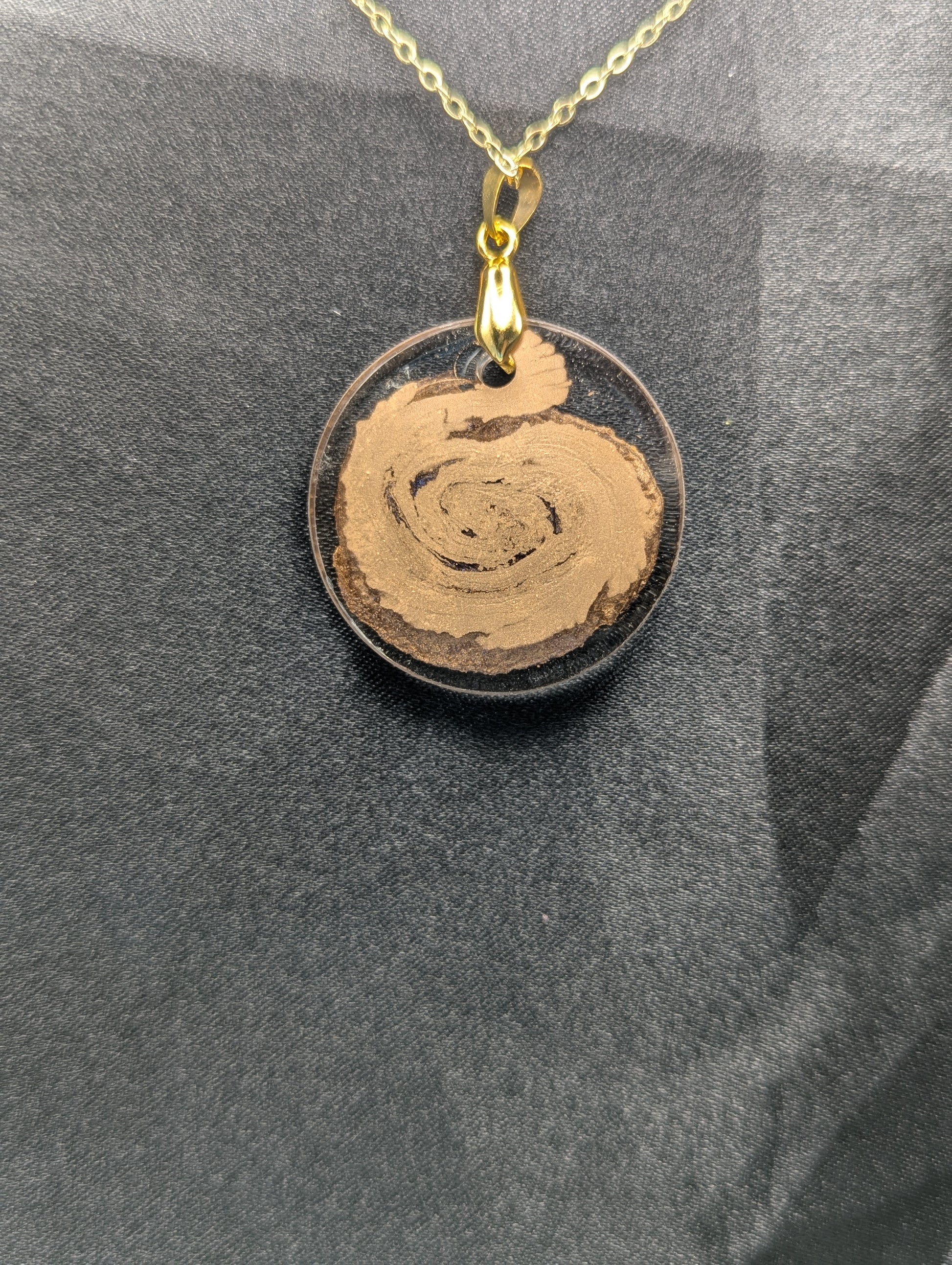 Back view of Gold Swirl Resin Circle pendant on a gold pinch bail and gold plated metal chain.