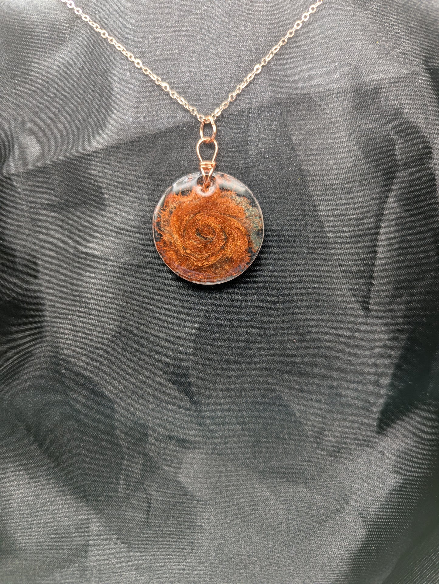 Copper swirl resin circle pendant, wrapped in a pure copper wire on a rose gold colored stainless steel plated metal chain.
