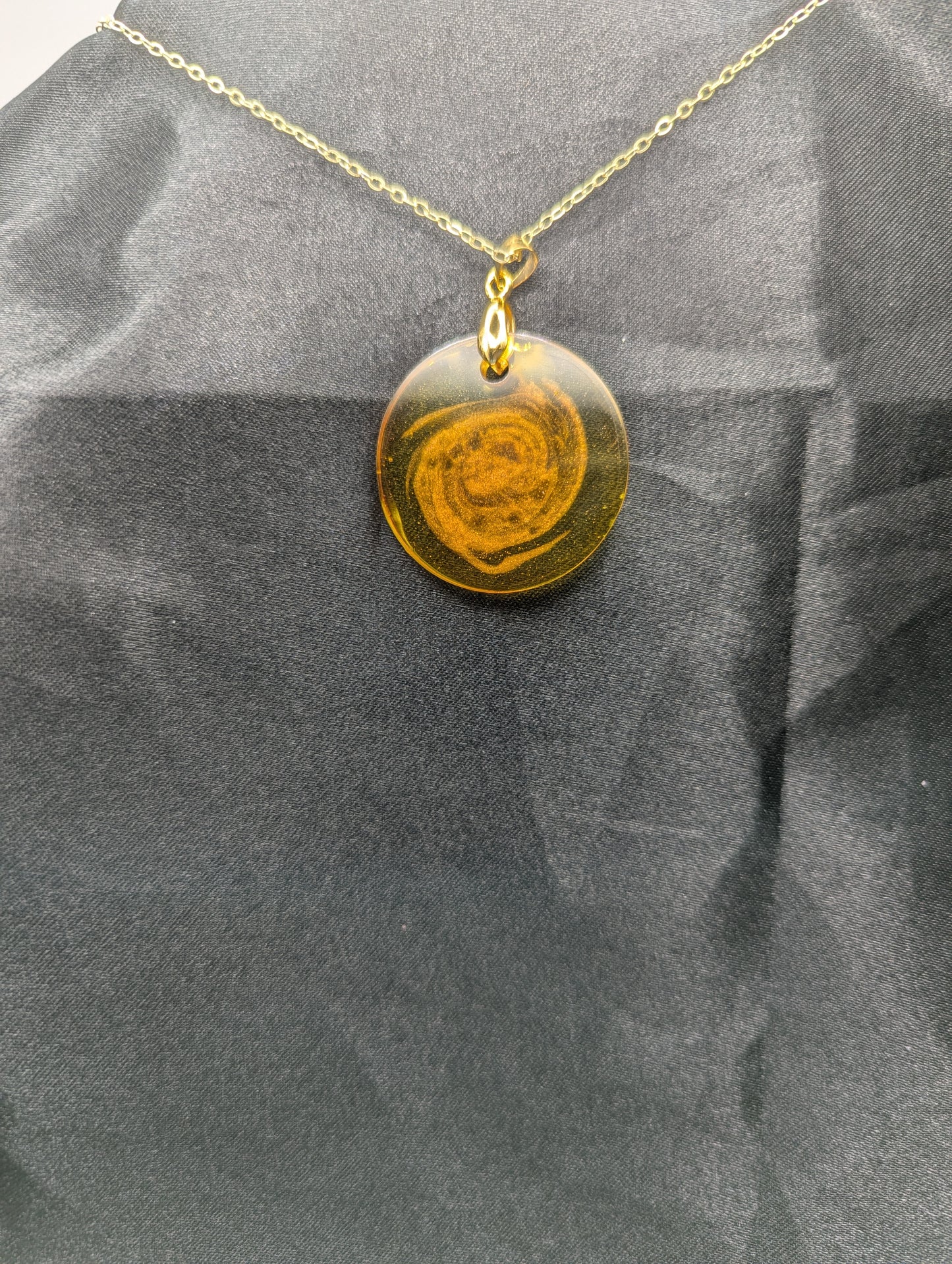 Back view of Yellow & Orange Swirl Resin Circle pendant on a gold pinch bail & gold plated metal chain