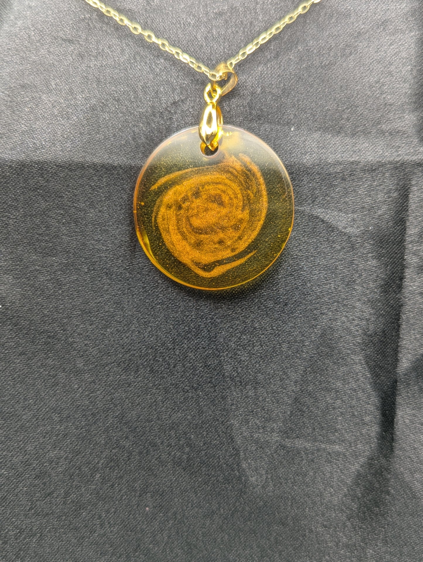 Back view of Yellow & Orange Swirl Resin Circle pendant on a gold pinch bail & gold plated metal chain