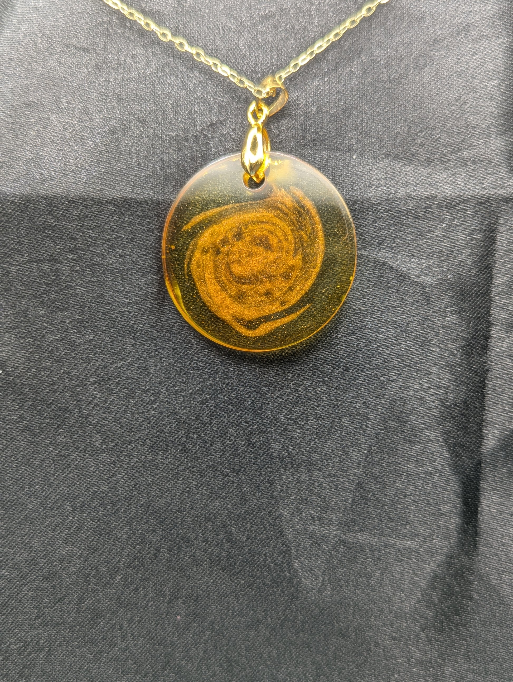 Back view of Yellow & Orange Swirl Resin Circle pendant on a gold pinch bail & gold plated metal chain