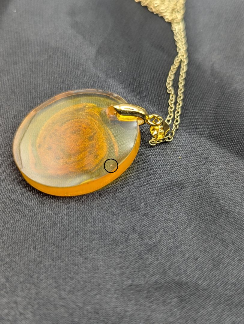 Yellow & Orange Swirl Resin Circle pendant on a gold pinch bail & gold plated metal chain
