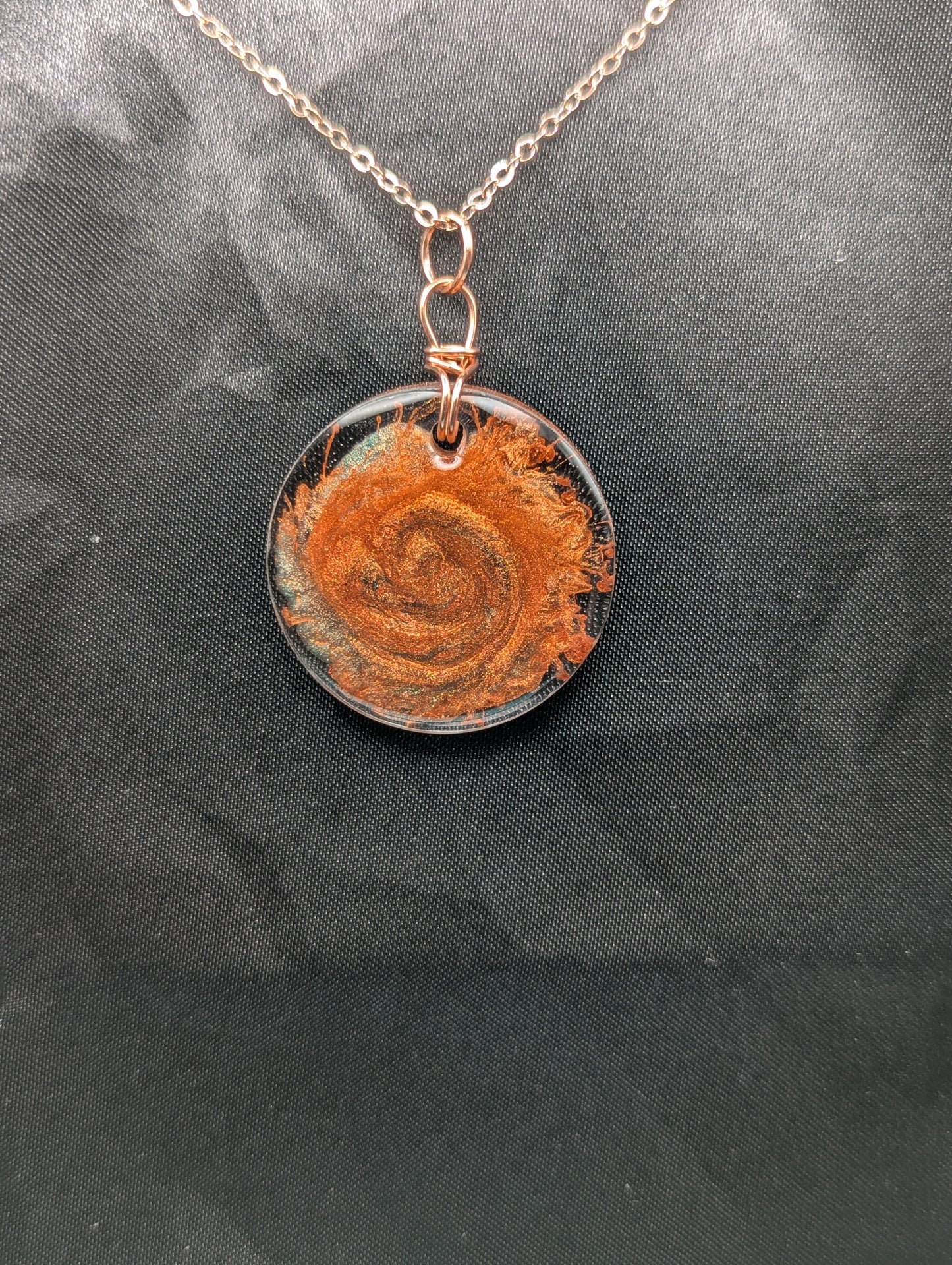 Copper Swirl Circle Resin Pendant wrapped in a pure copper wire on a rose colored stainless steel plated metal chain.