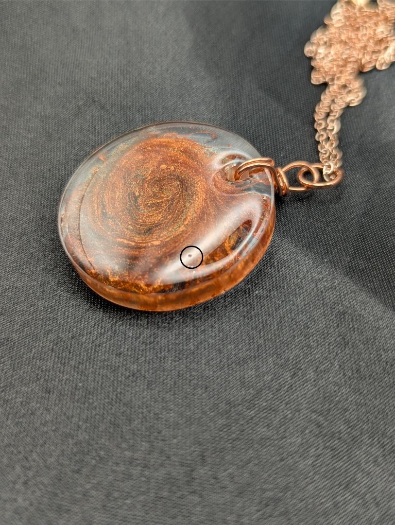 Copper Swirl Circle Resin Pendant wrapped in a pure copper wire on a rose colored stainless steel plated metal chain.