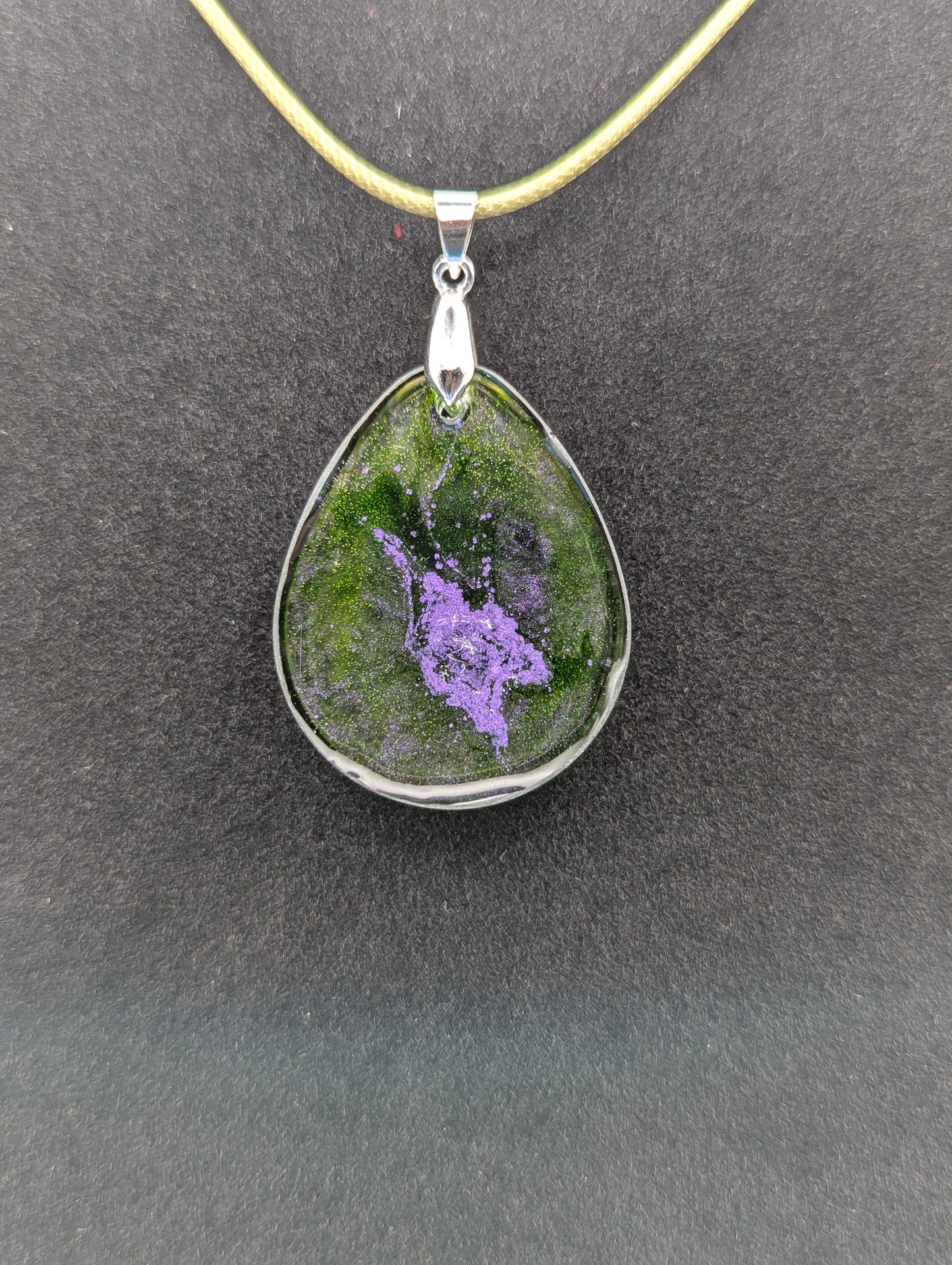 Back view of Teardrop Resin Pendant Necklace - Green & sparkly in color with pops of purple. Resin necklace on a waxed cotton cord.