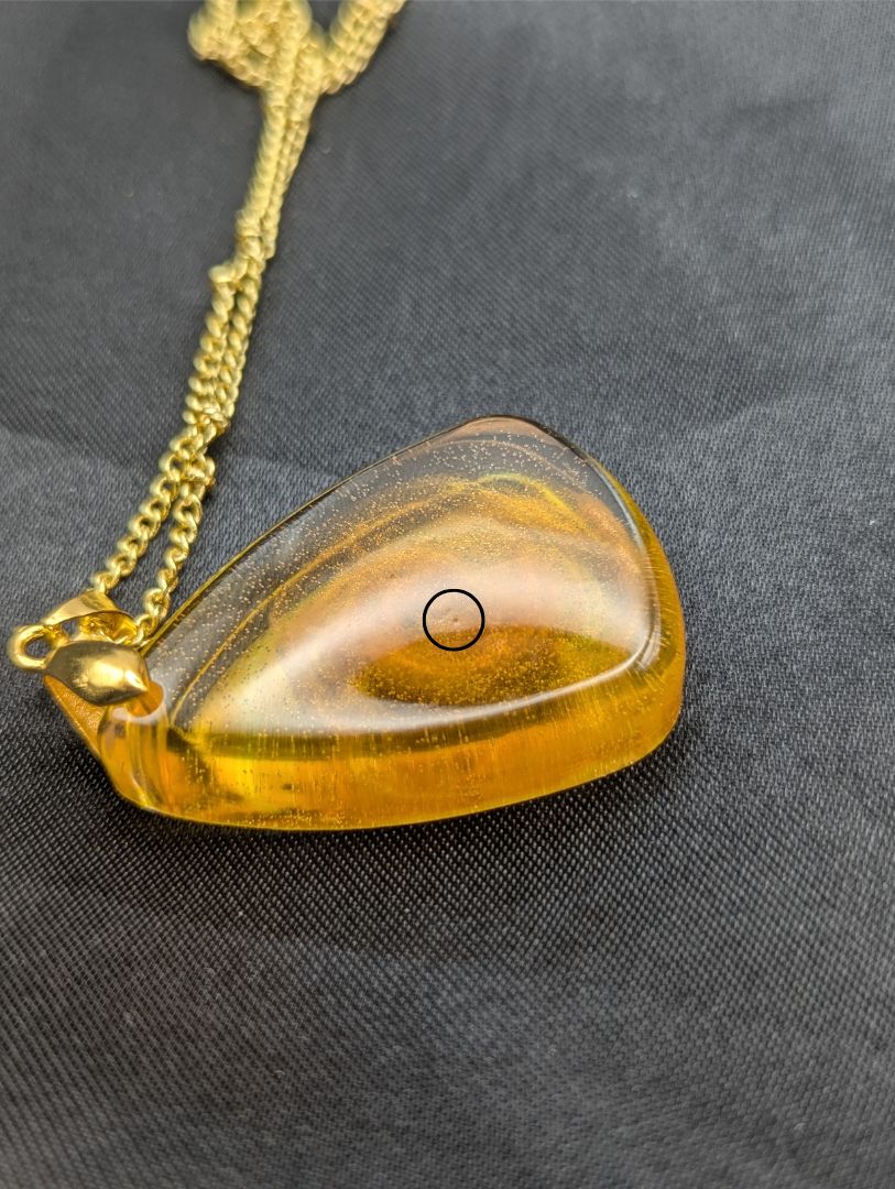 Yellow & Orange Swirl Rounded Triangle Resin Pendant Necklace on a gold pinch bail and a gold plated metal chain.