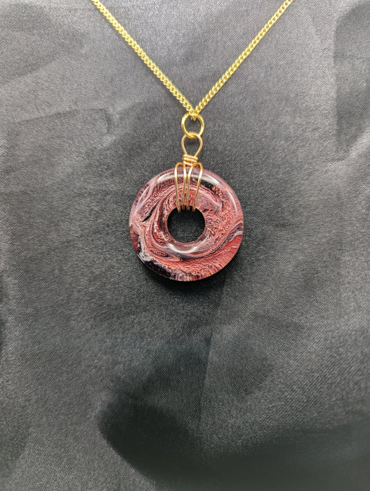 Wire Wrapped Donut Resin Pendant Necklace - Petri Effect with shades of red & black swirls. Resin Necklace on a gold plated metal chain.